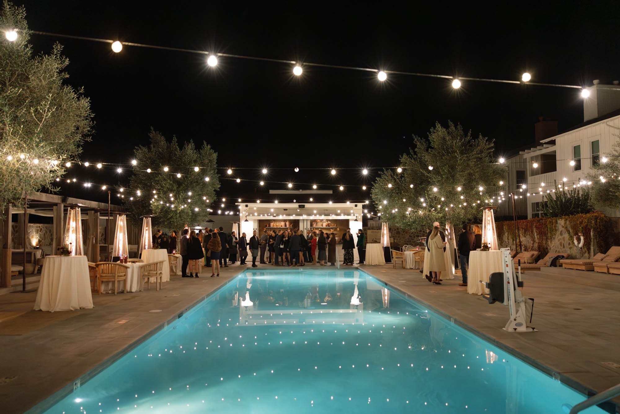 Guests at a poolside welcome party the night before a Mattei's Tavern wedding