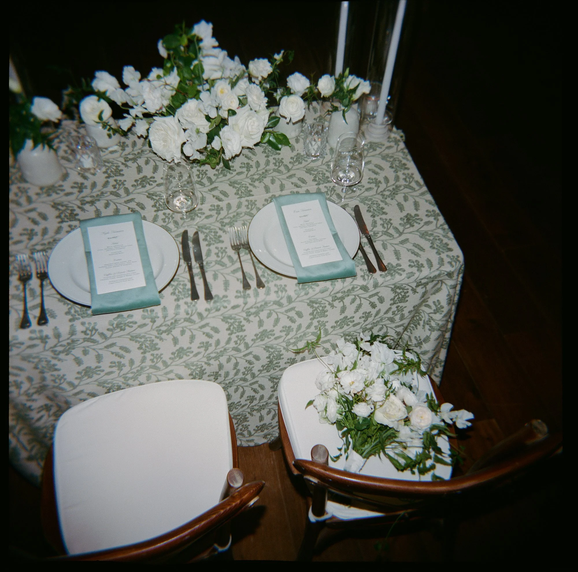 Editorial reception detail of patterned linen, menus, and white floral arrangement at the Inn at Mattei's Tavern