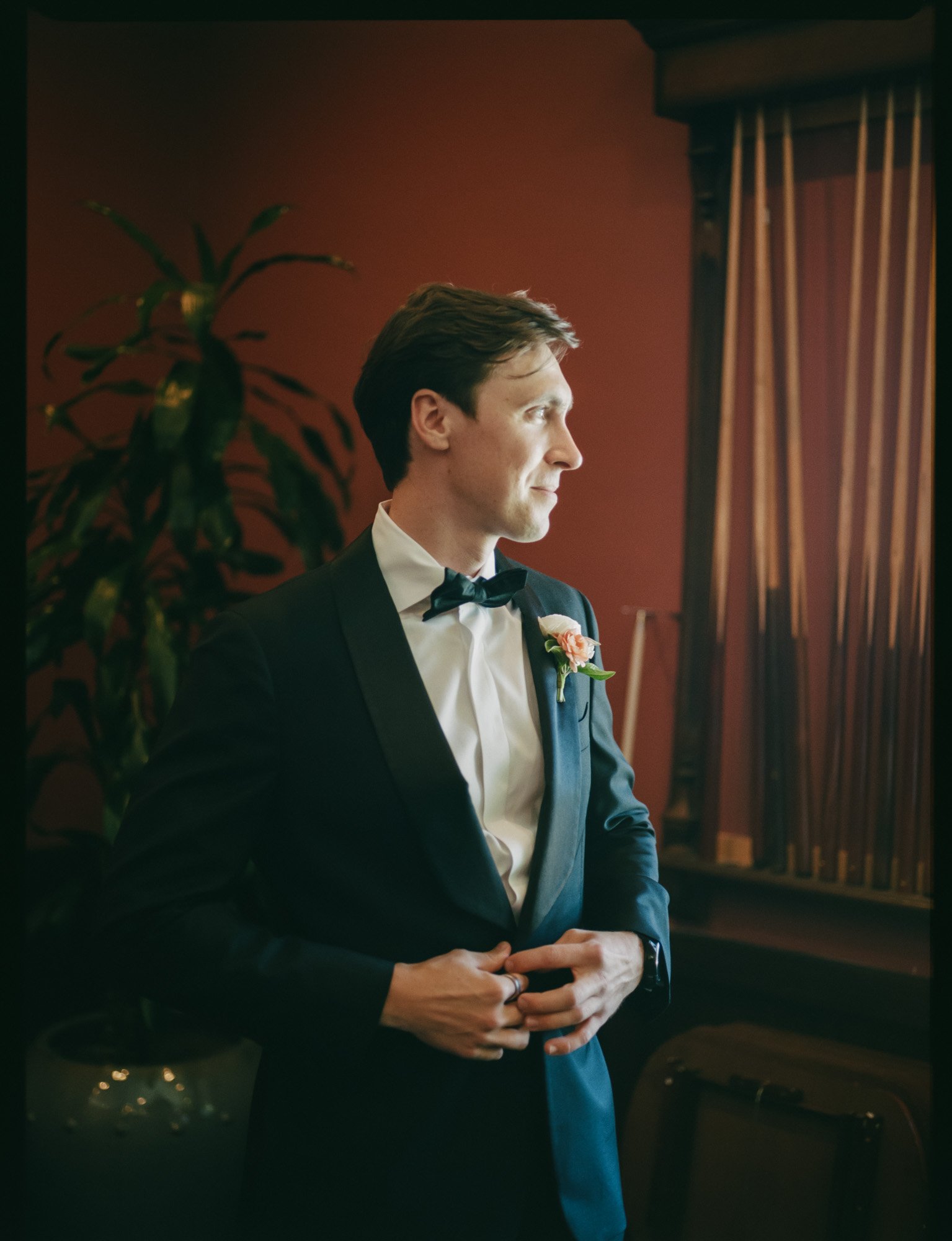 Groom portrait in classic black tuxedo photographed in an editorial wedding photography style on medium format film at a Santa Barbara wedding venue.