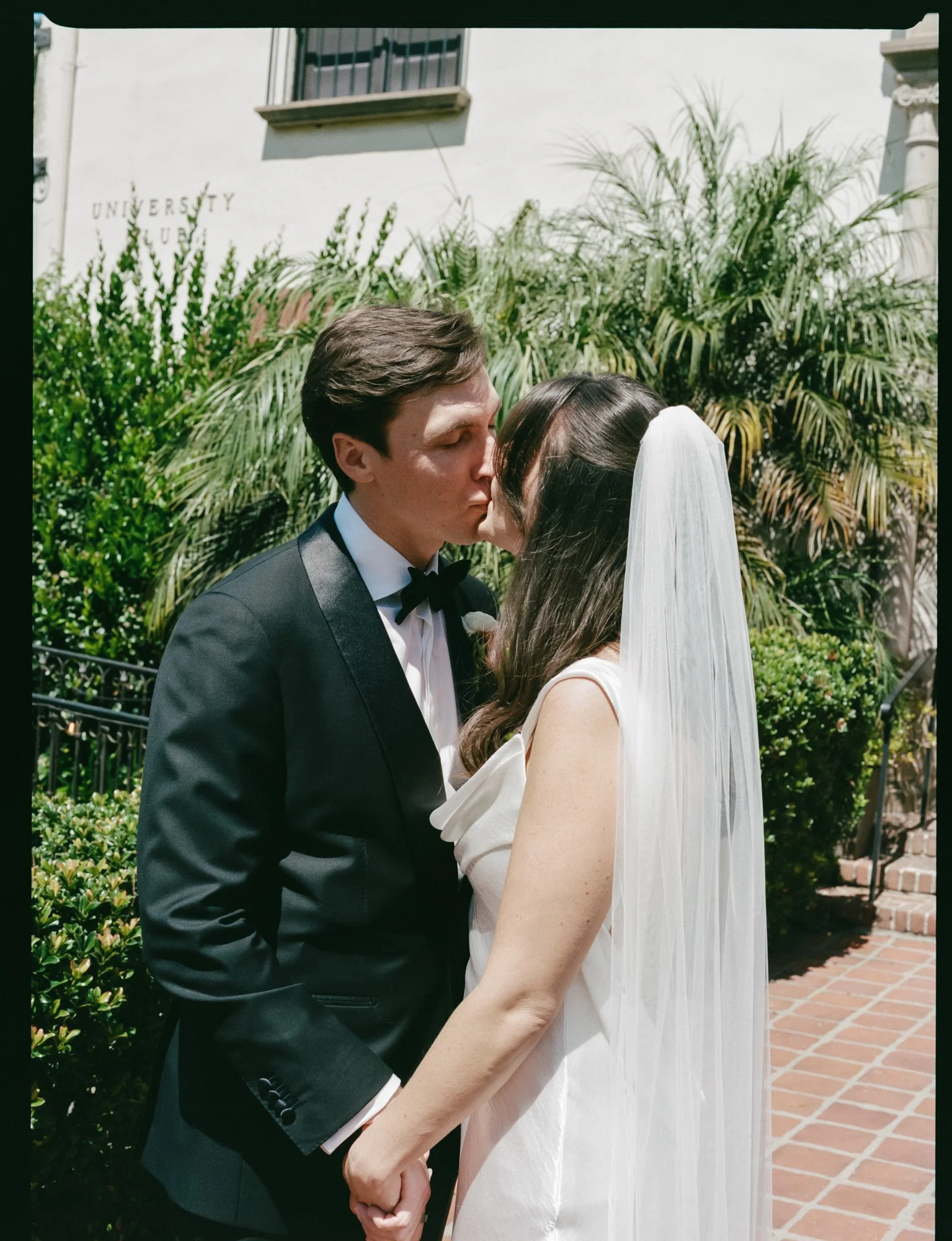 Bride and groom kissing during an outdoor California wedding portrait session. Photographed on medium format film on a Santa Barbara wedding day. 