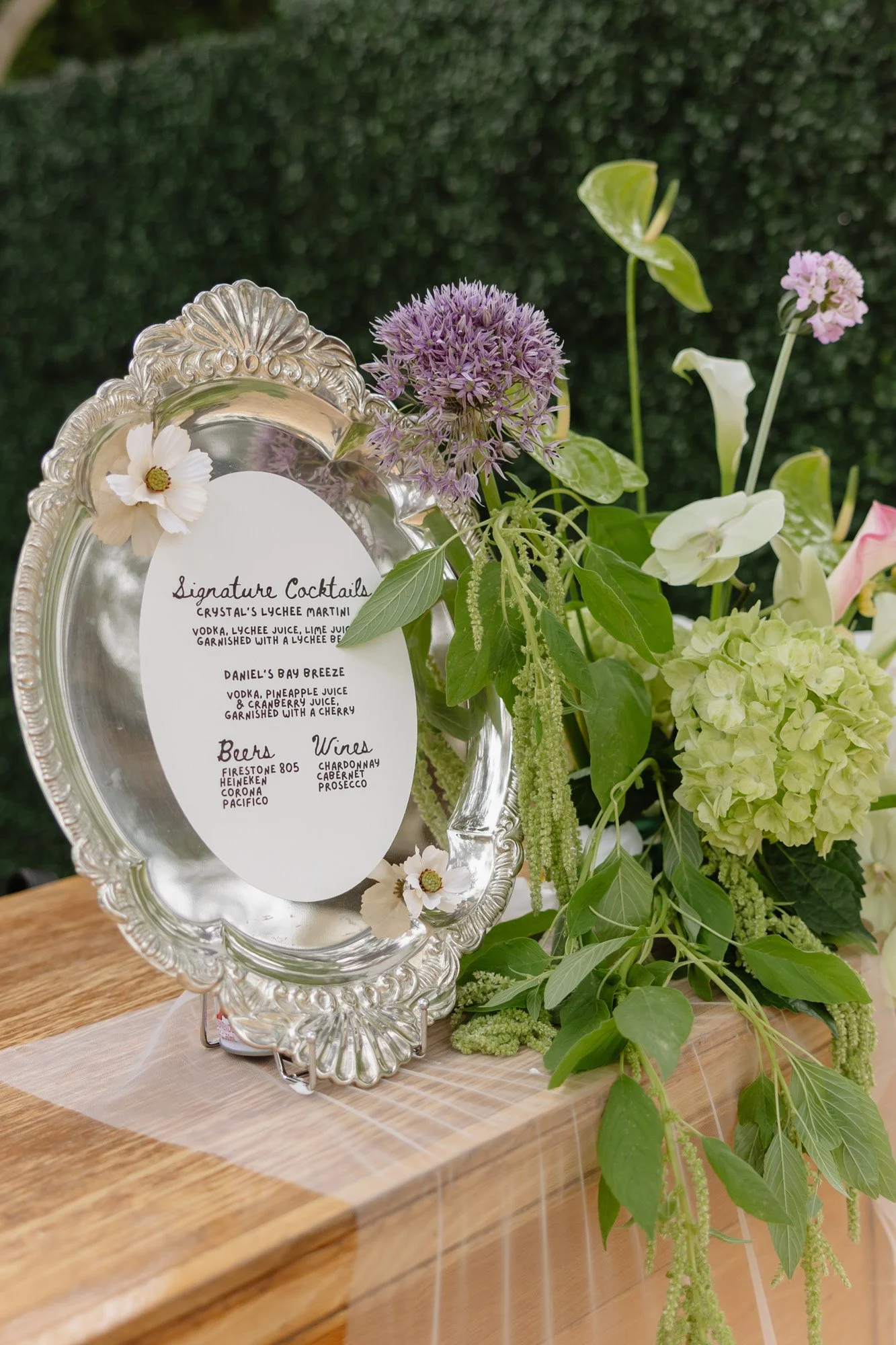 Framed wedding welcome sign surrounded by garden flowers at a Santa Barbara style wedding