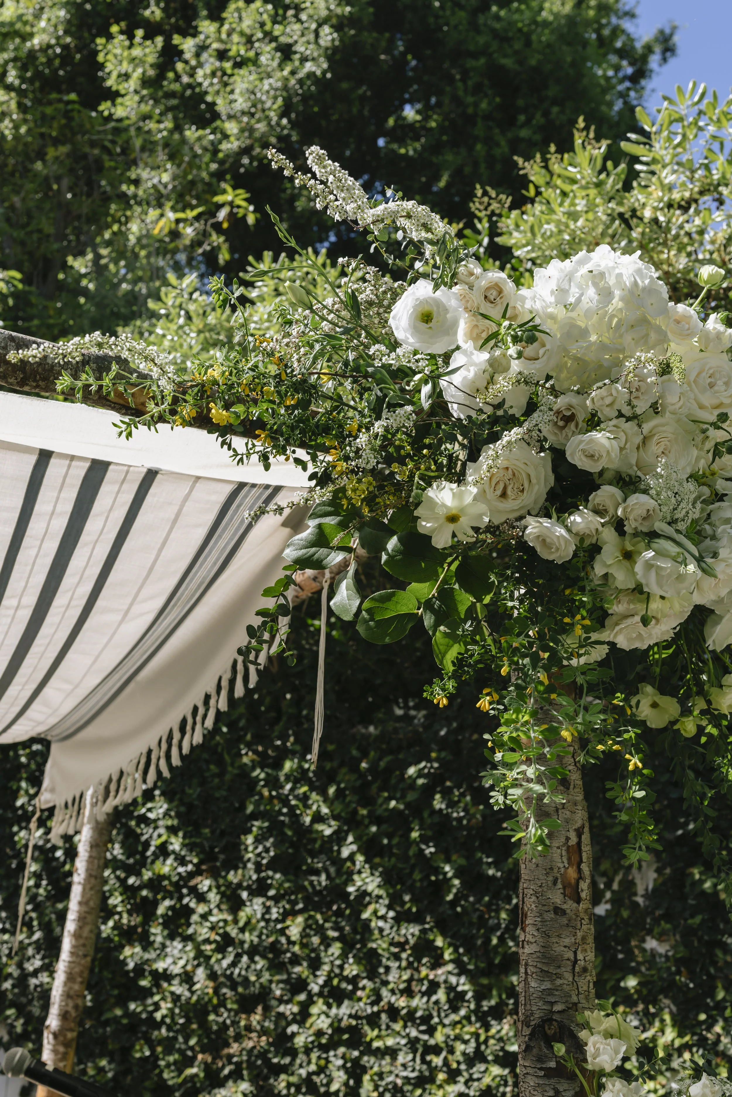 White floral wedding ceremony arch with chuppah at a California estate wedding