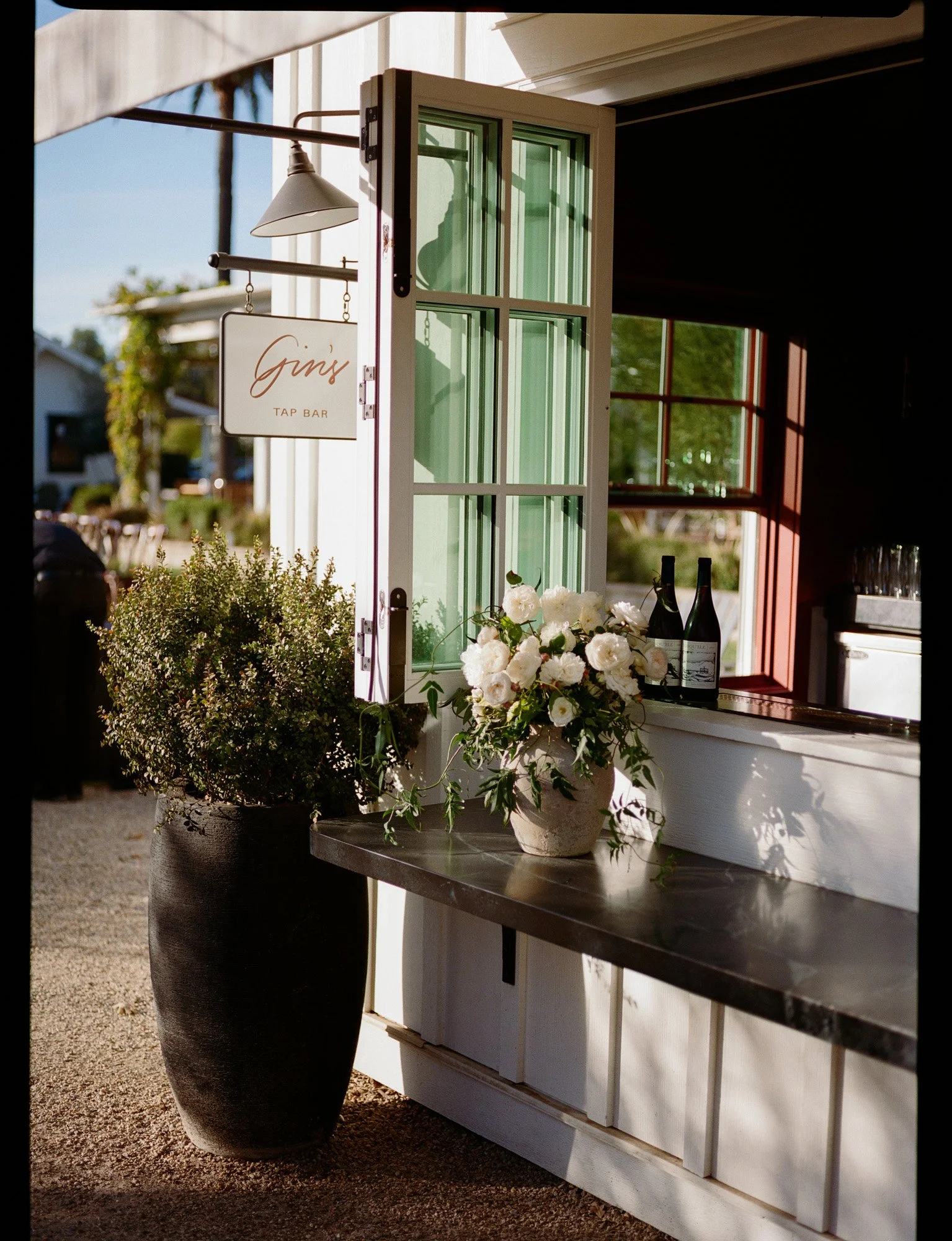 Editorial wedding welcome bar at a luxury California wedding venue, The Inn at Mattei's Tavern, with floral arrangements and signage