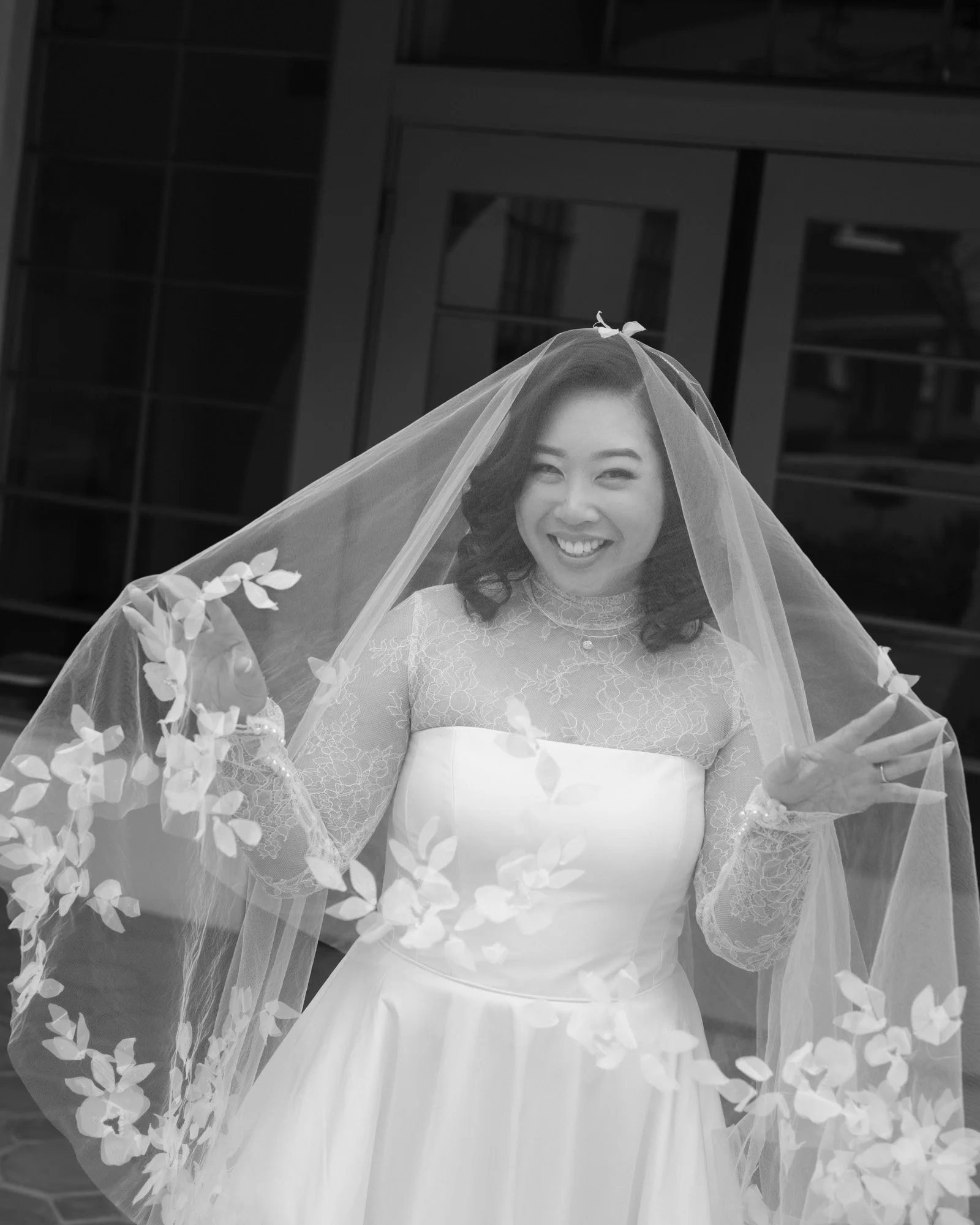 Black and white bridal portrait beneath lace veil before a California wedding ceremony