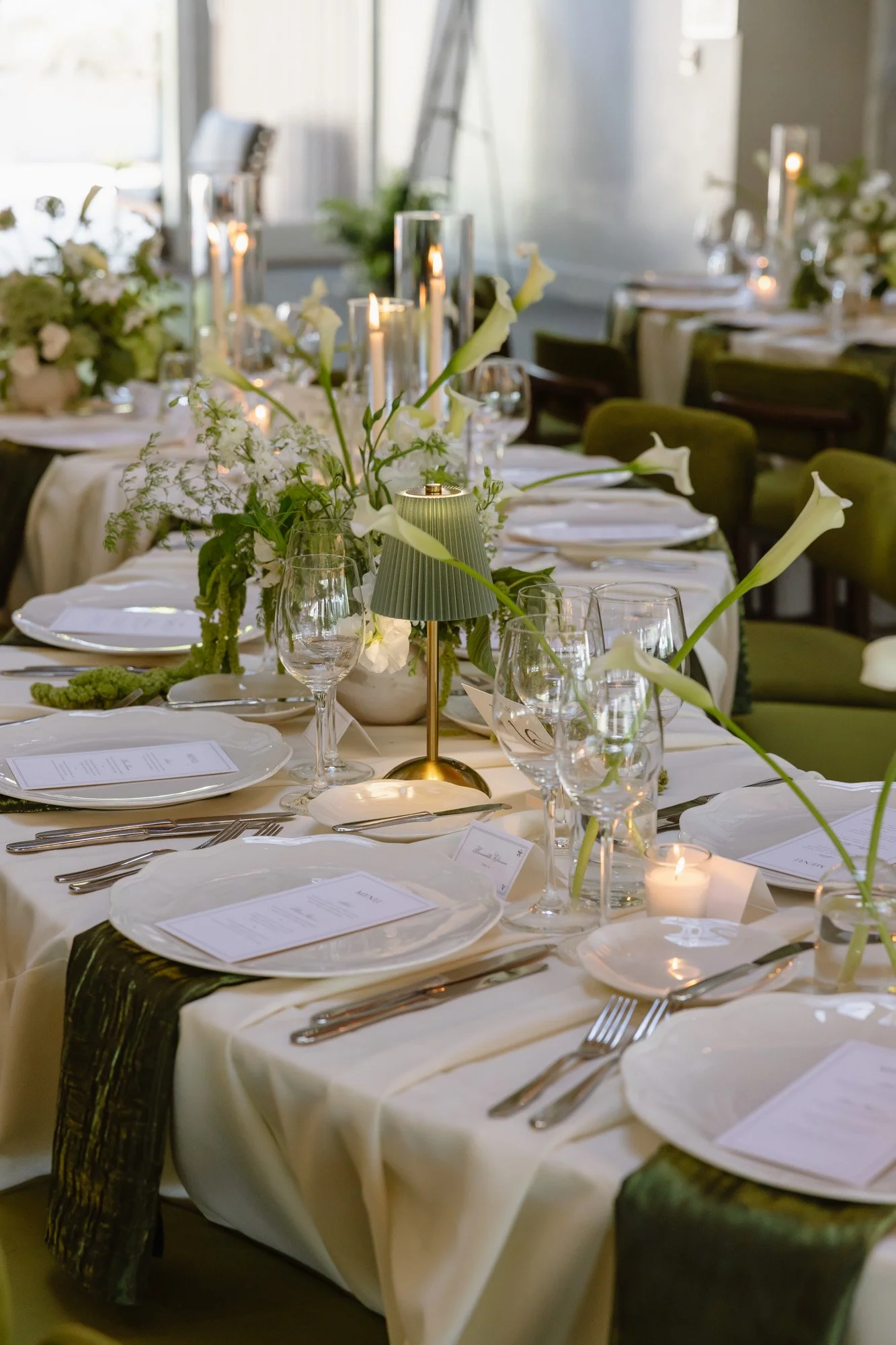 Candlelit reception table with white florals and green chairs at a luxury California wedding