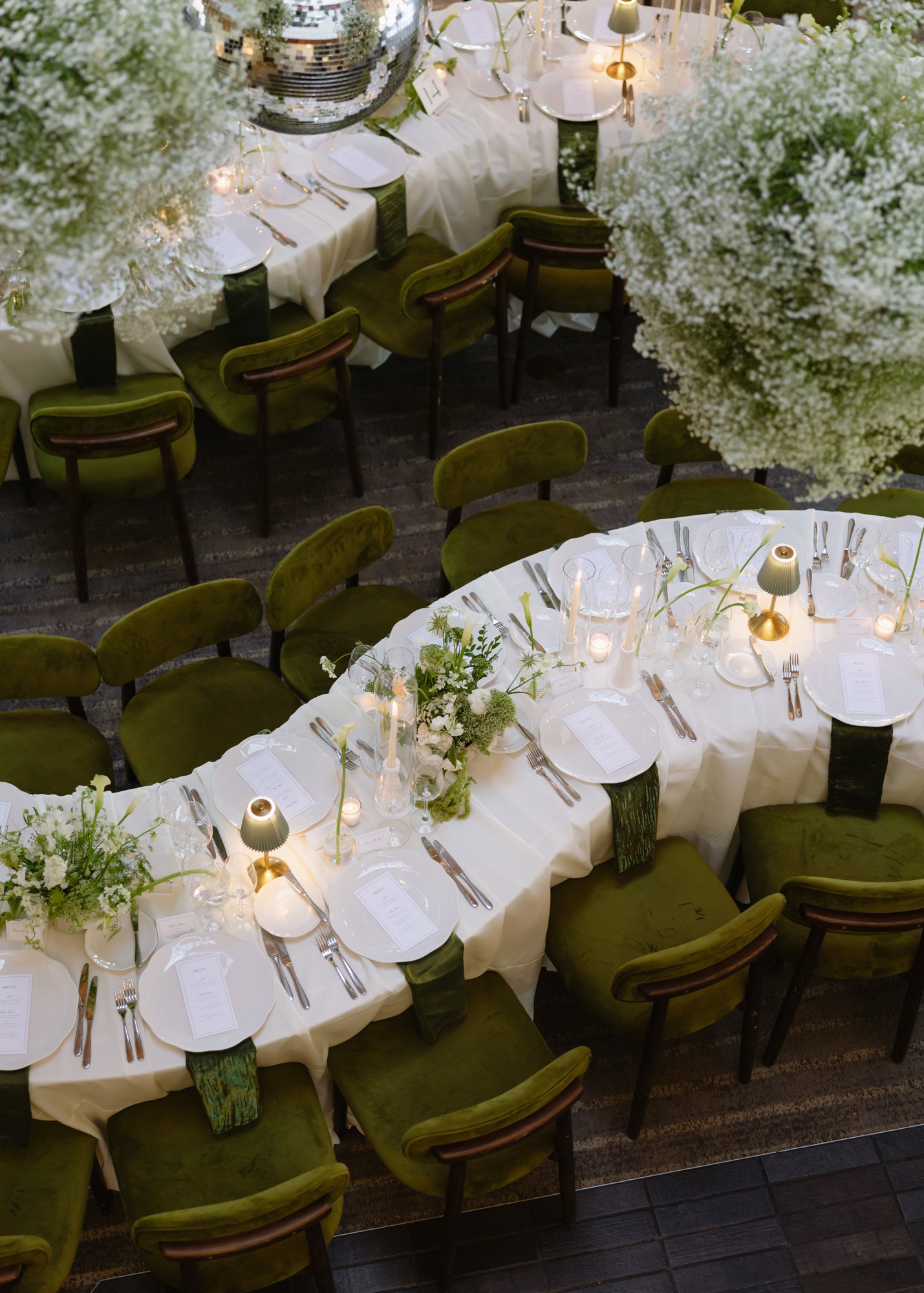 Candlelit wedding reception tablescape with green chairs and white florals at a California destination wedding at the Carmel Valley Ranch