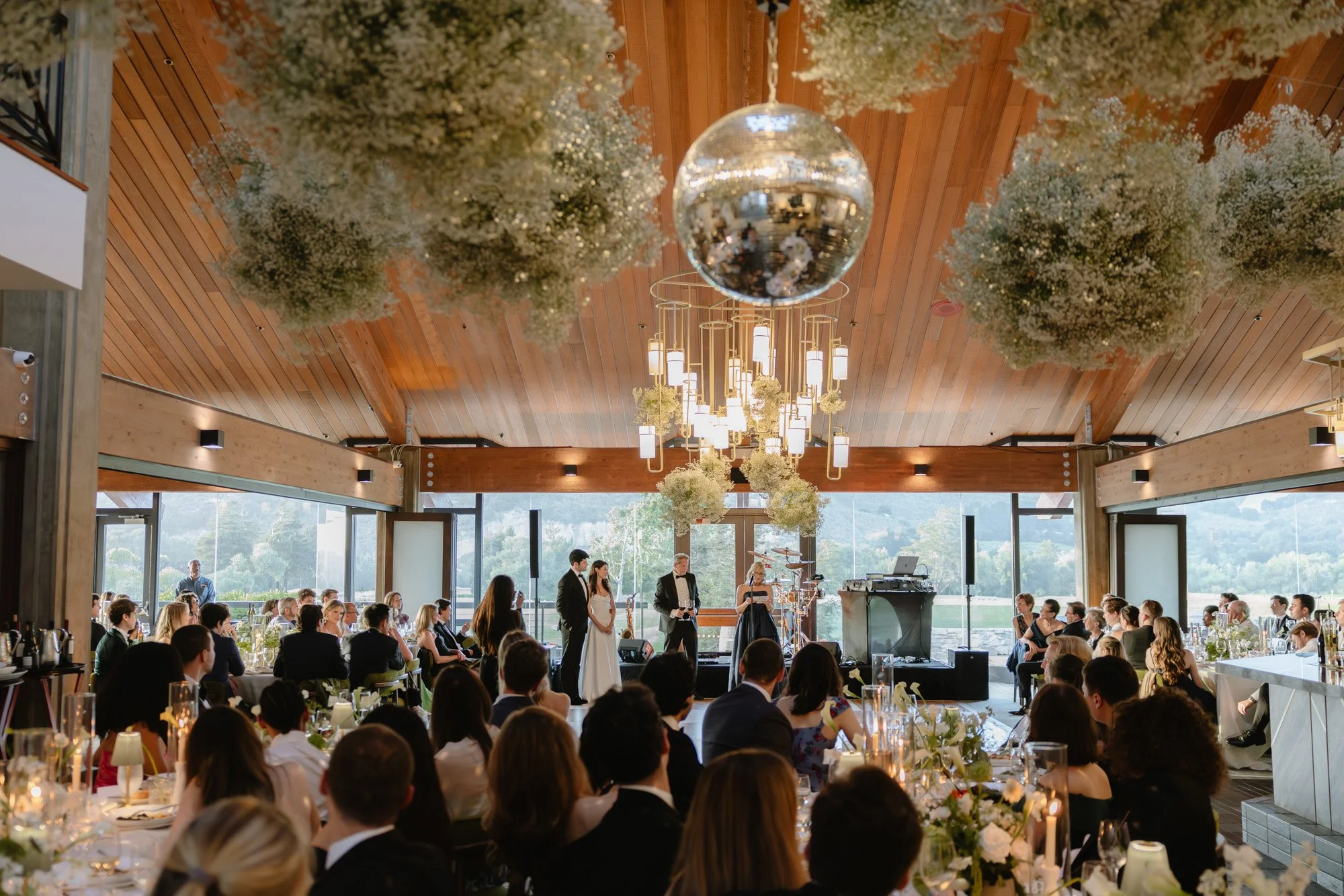 Luxury tented wedding reception with disco ball and candlelit tables in California. Documentary style reception moment at the Carmel Valley Ranch.