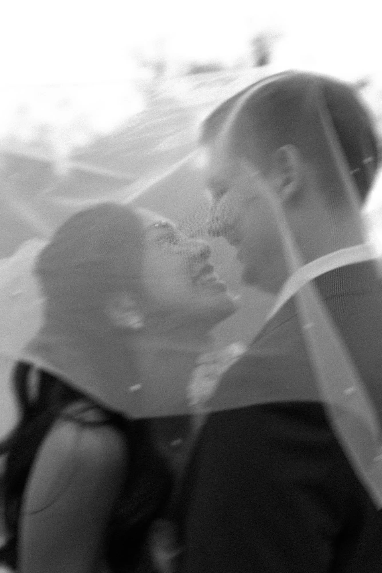 Soft-focus film wedding portrait of bride and groom under a veil at a California wedding