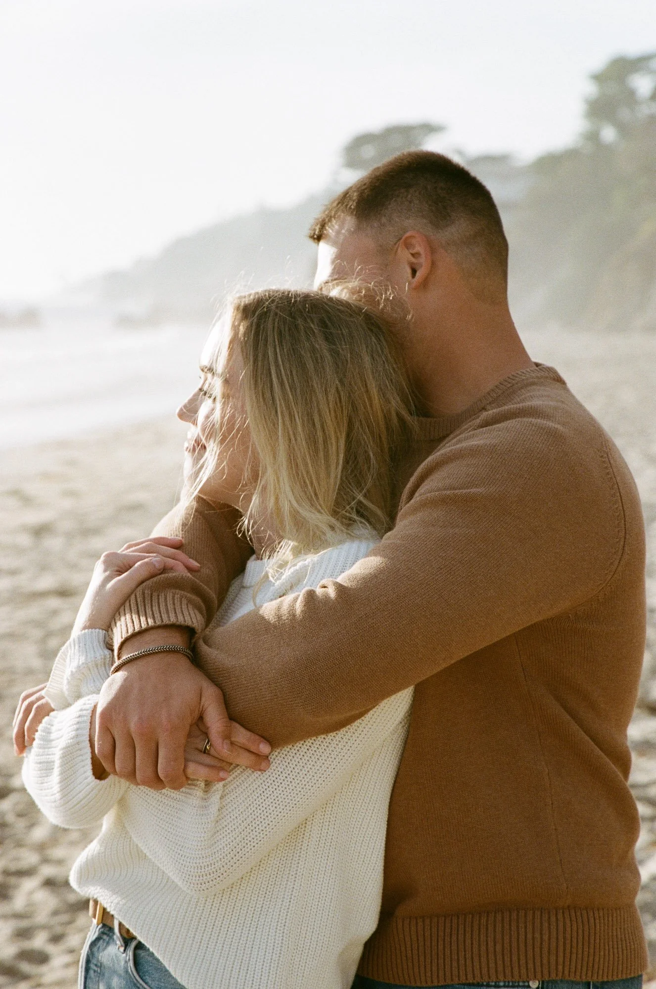 A couple hugging on a beach.