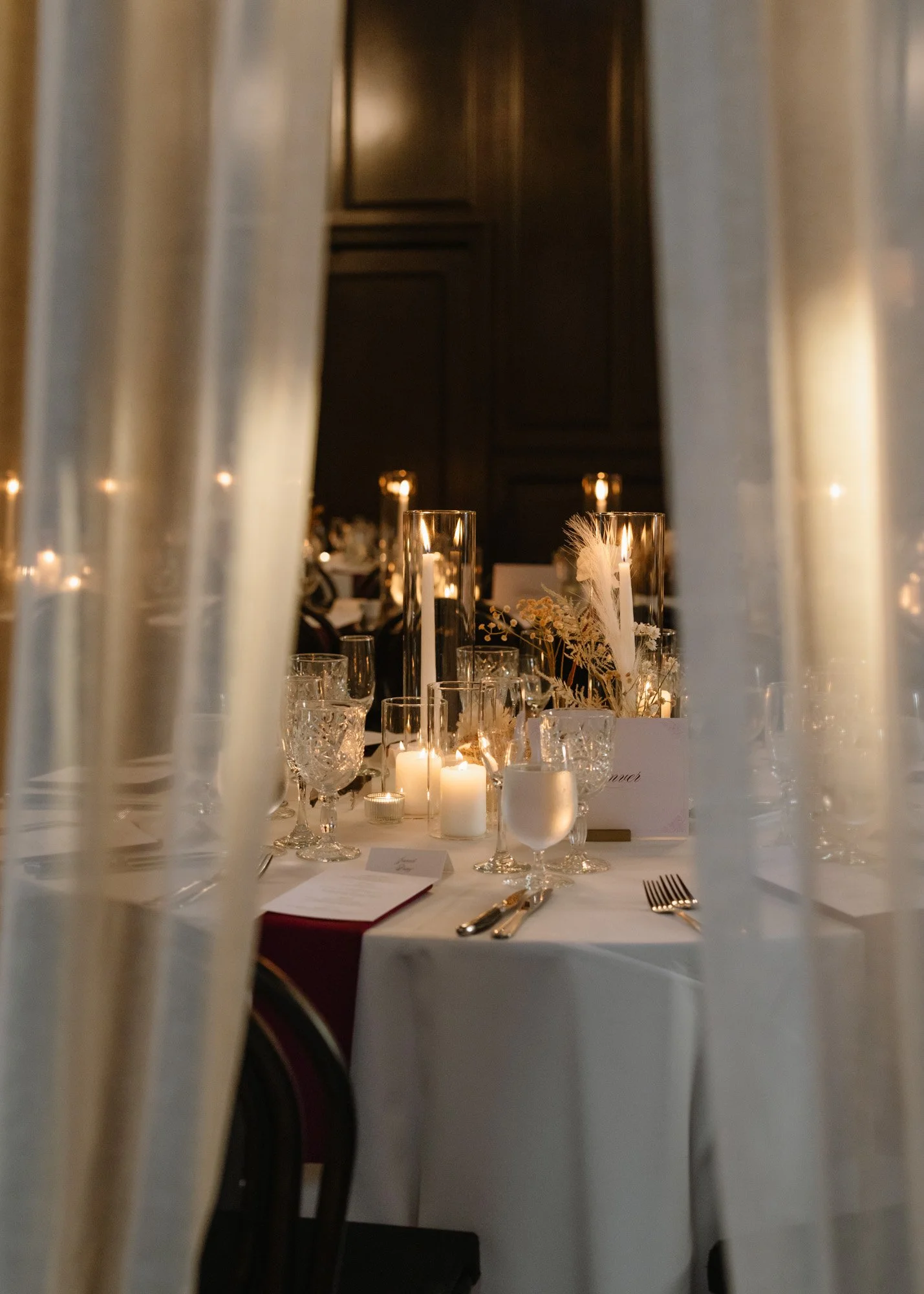 Candlelit wedding reception table photographed through soft drapery at the Ebell of Long Beach