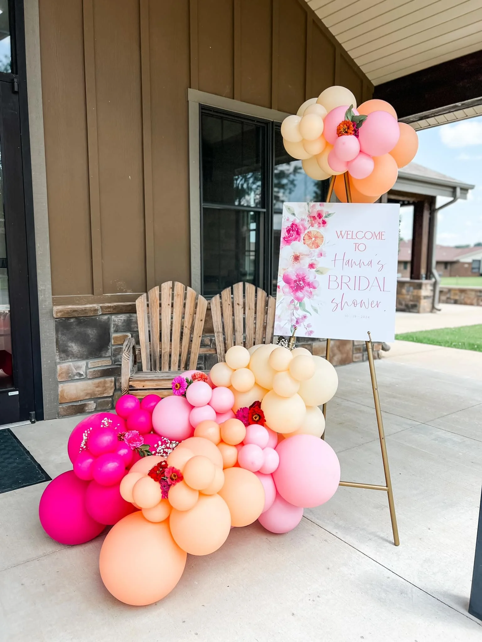 Decorative balloon arrangement in shades of pink, peach, and cream with a welcome sign for a bridal shower.