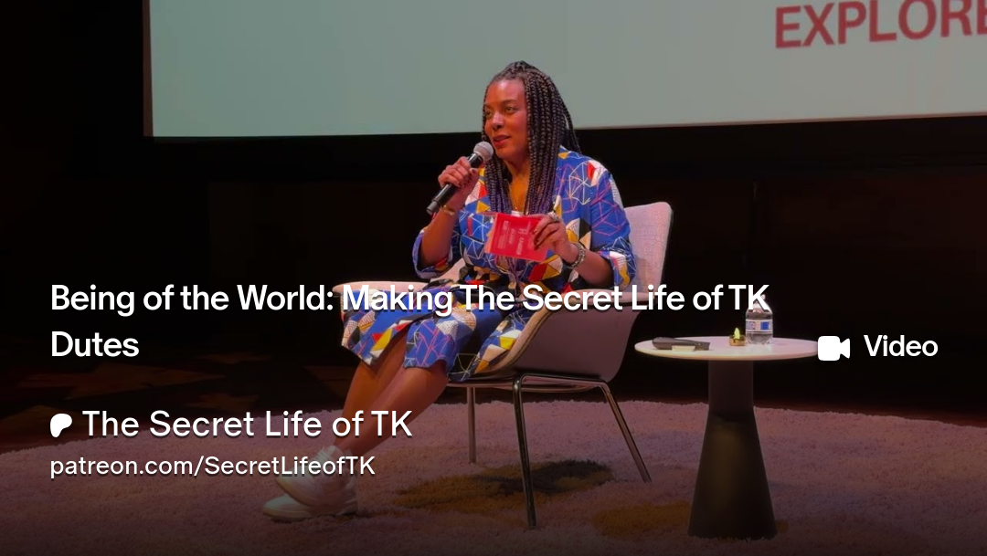 TK seated wearing a blue dress at resonate podcast festival. Gving a speech about her podcast The Secret Life of TK Dutes