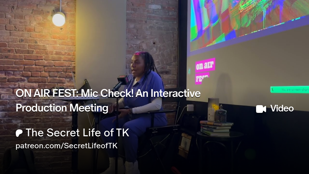 TK in a blue jumpsuit seated in a director's chair in front of a movie screen at on air fest, conducting a live production meeting