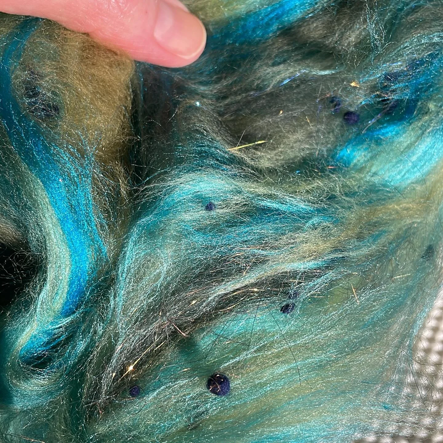 Mixed media roving made from a hand-carded batt. Merino wool in oceanic shades with glints of metallic Angelina fiber. π #fiberart #fiberart_community #fiberart