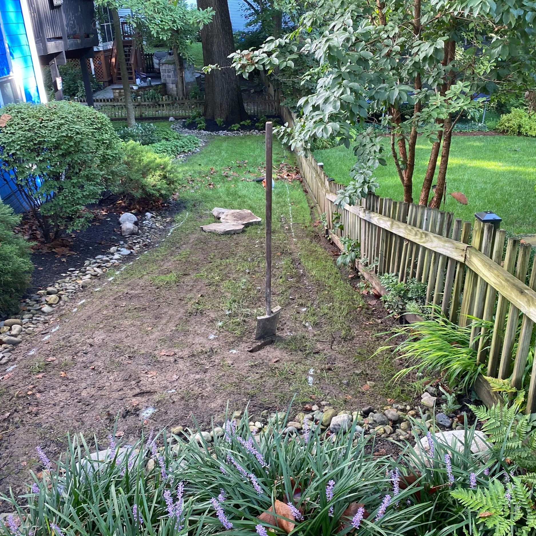 Muddy slope with a shovel standing in the soil.