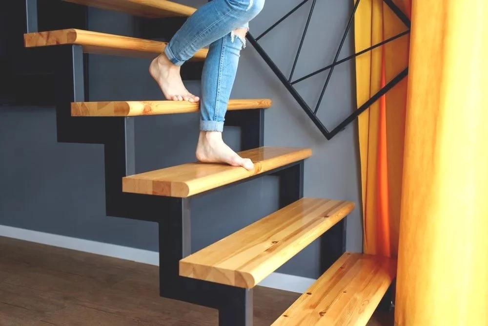 Person stepping up a staircase, emphasizing controlled movement and balance.