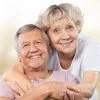 Elderly couple smiling and embracing