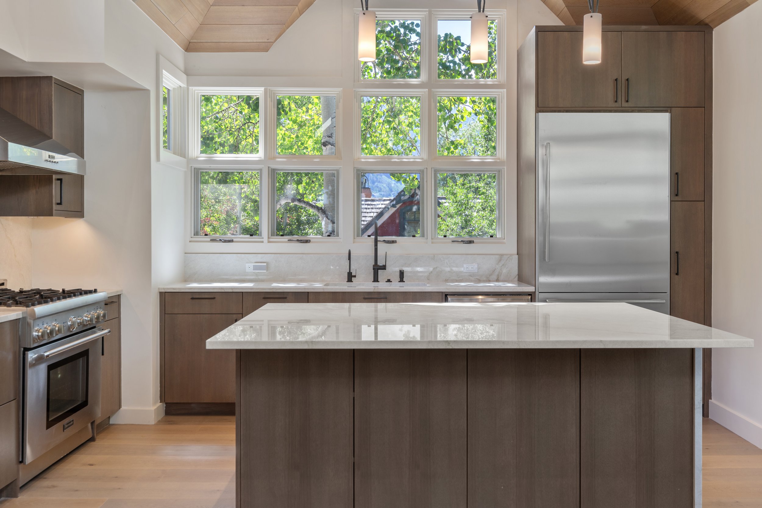 Custom kitchen with quartzite countertops, professional range, and grid-style windows, Telluride, Colorado.