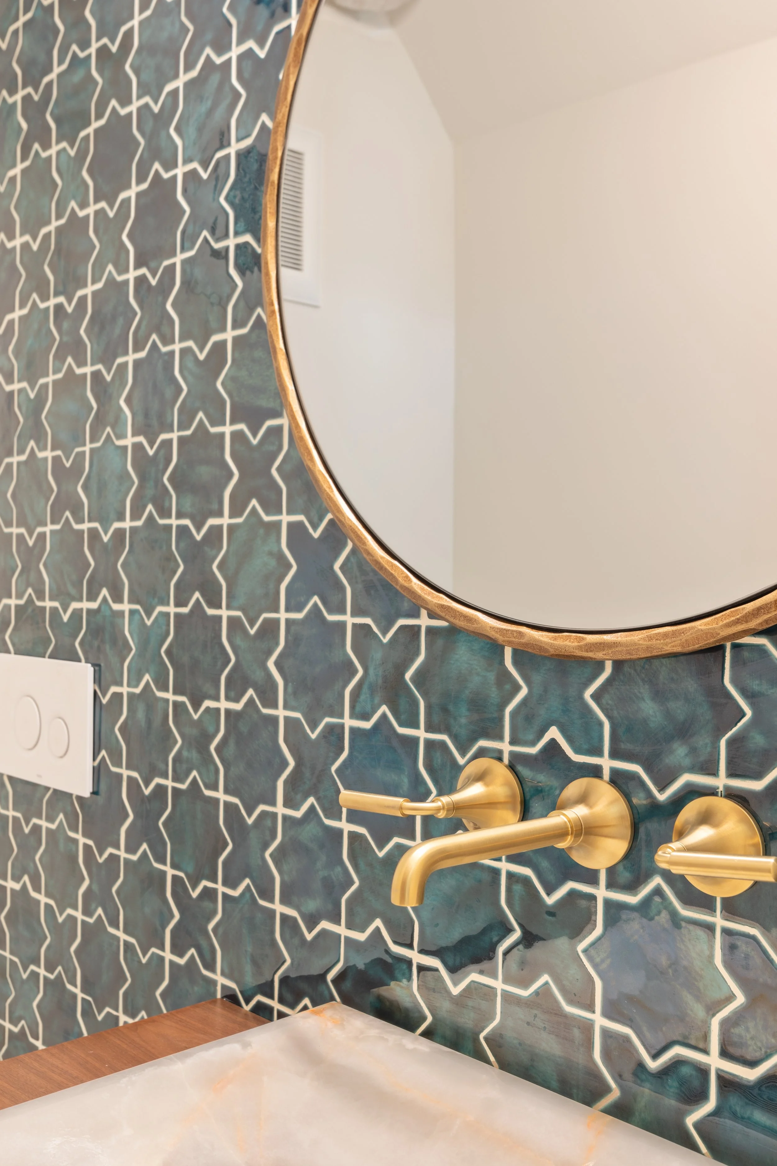 Moroccan star tile backsplash with round brass mirror and wall mount faucet, Telluride, Colorado home.