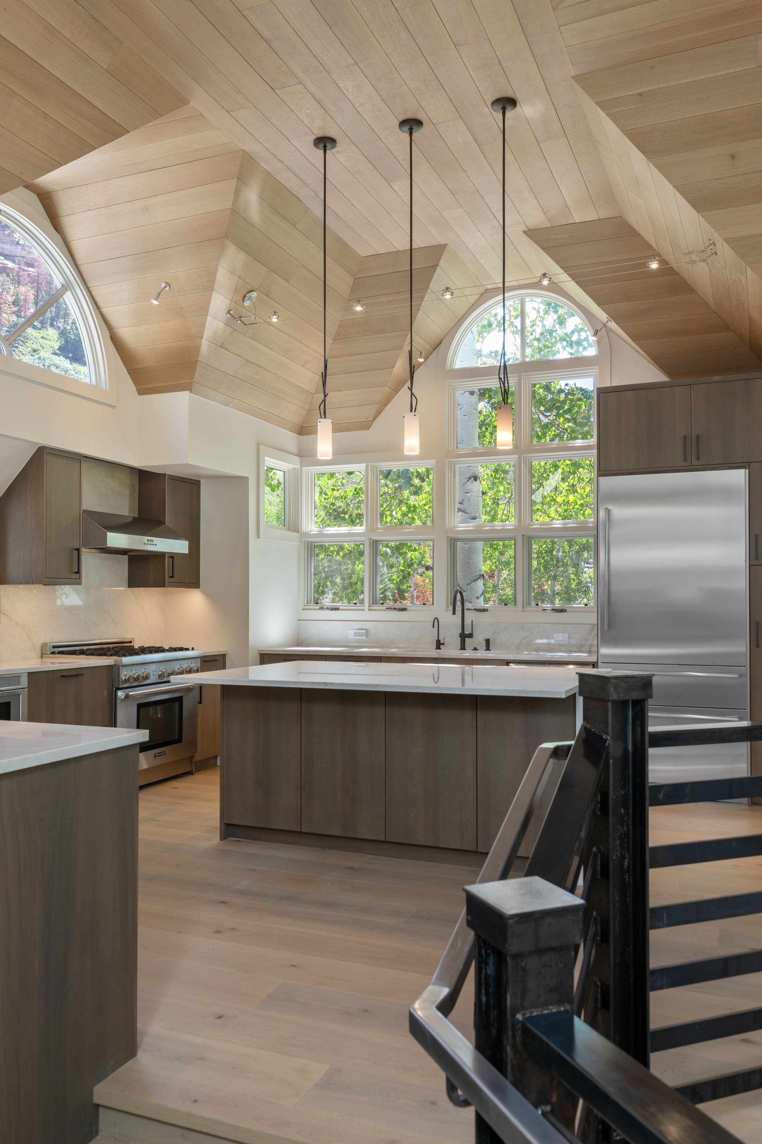 Open-concept kitchen with vaulted wood ceiling and arched windows, Telluride, Colorado home remodel.