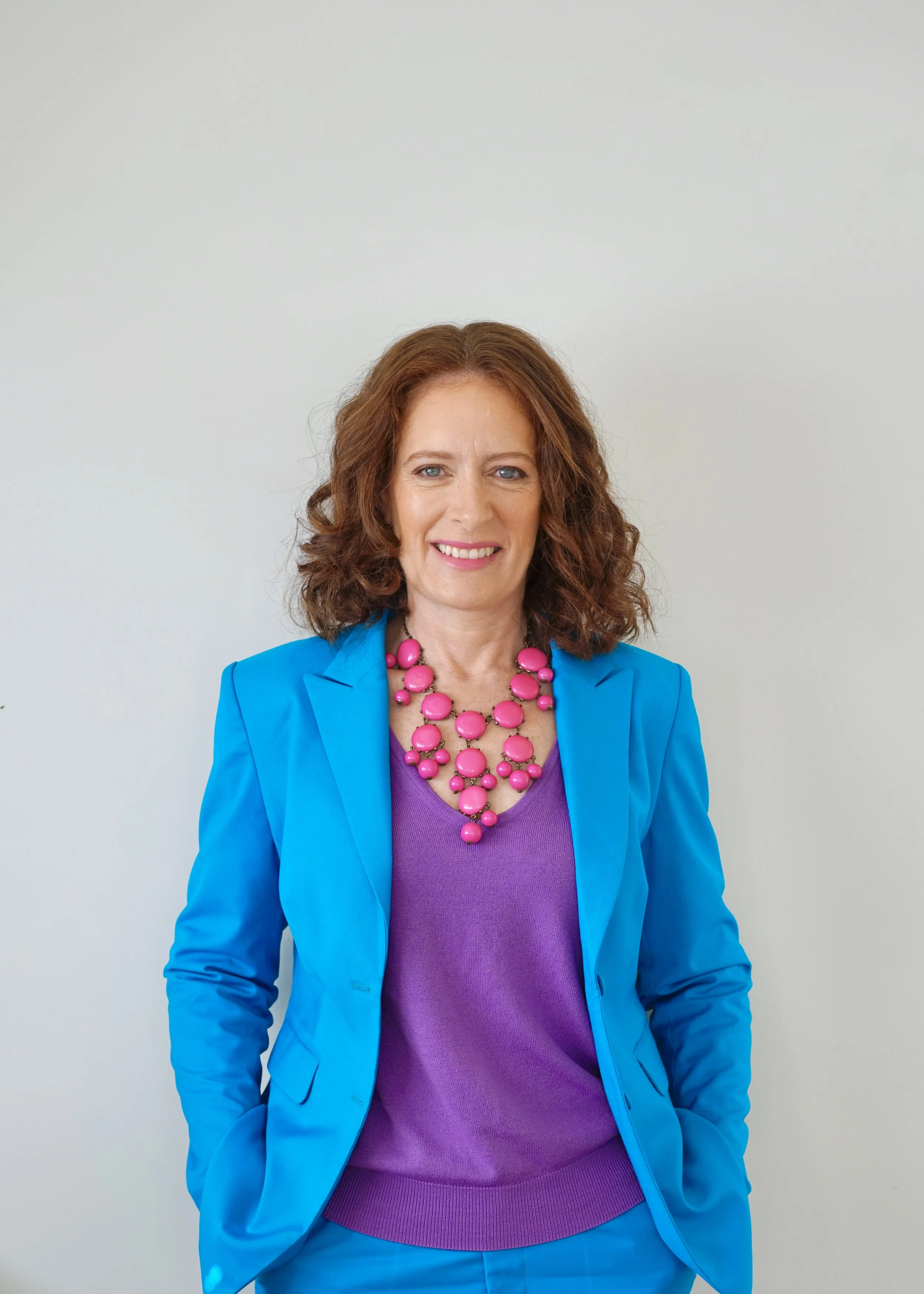 Carmel Murphy wearing confidence code colours pink purple blue smiling at camera