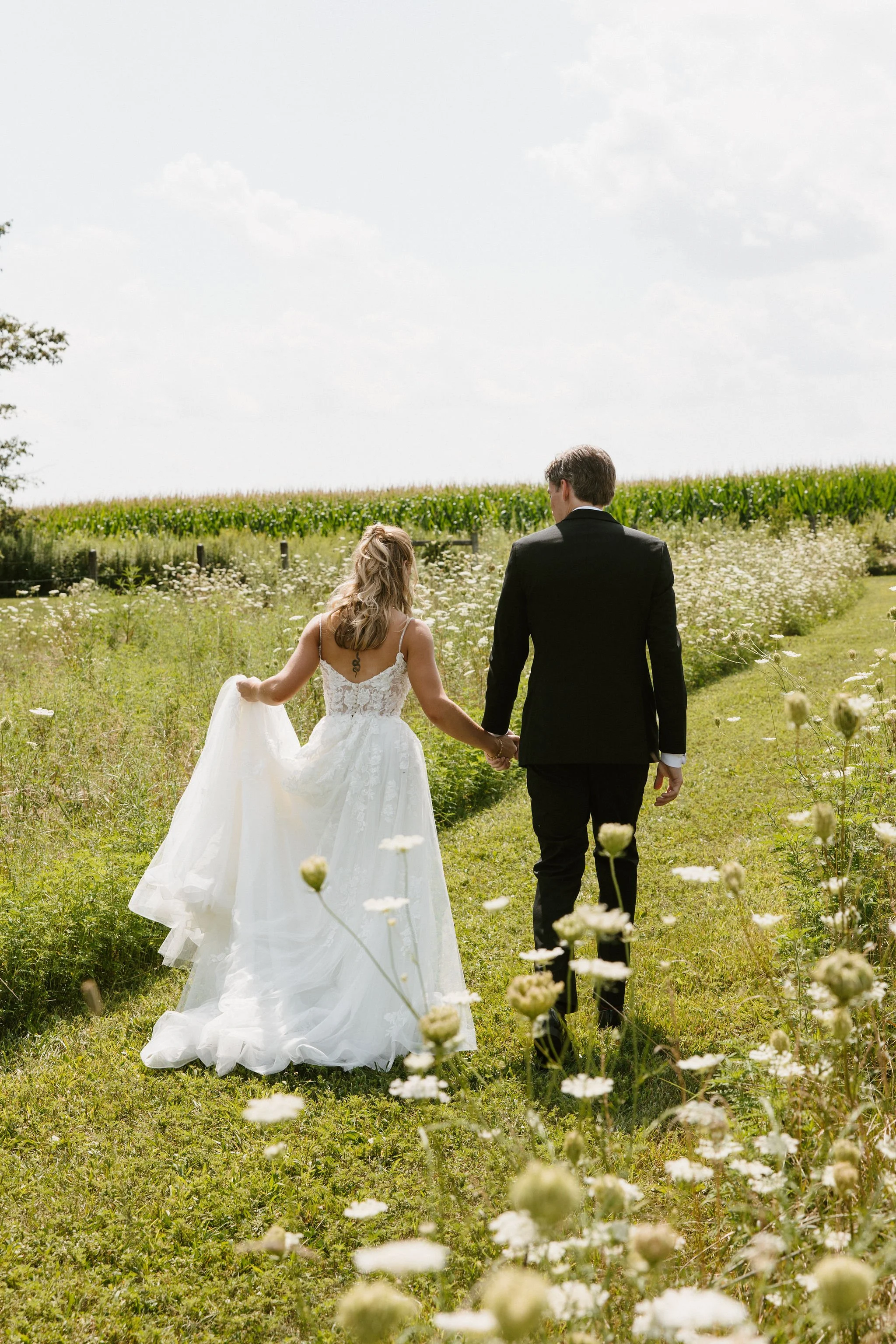 Bride and groom walking through the countryside grounds at Aspen & Alston near Columbus, Ohio
