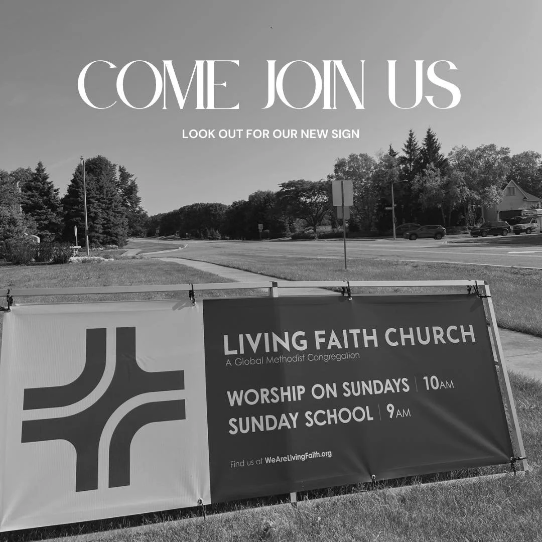 Sign for Living Faith Church with worship and Sunday school times, in front of a grassy area and street with trees and cars.