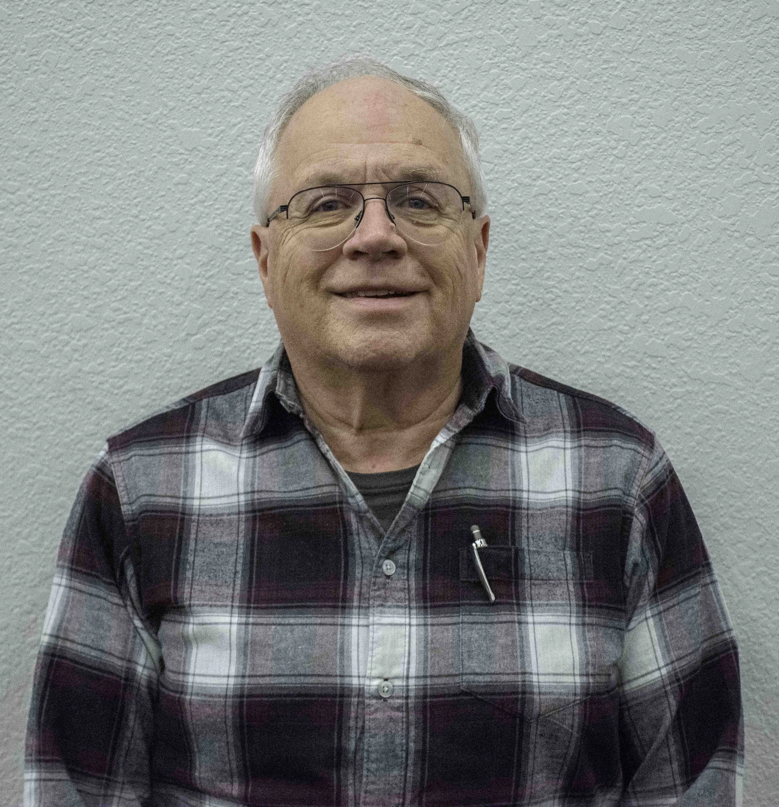 Man wearing a plaid shirt and smiling