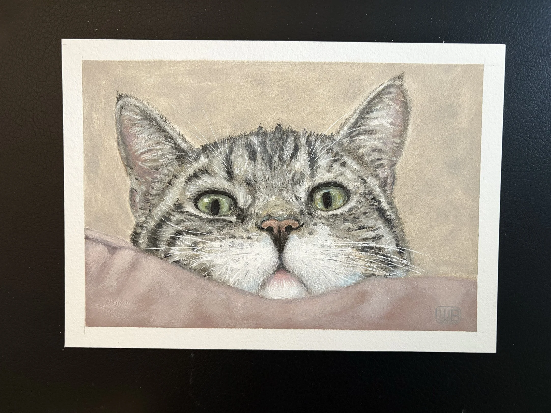 A realistic painting of a gray tabby cat with green eyes resting its head on a soft pink surface.