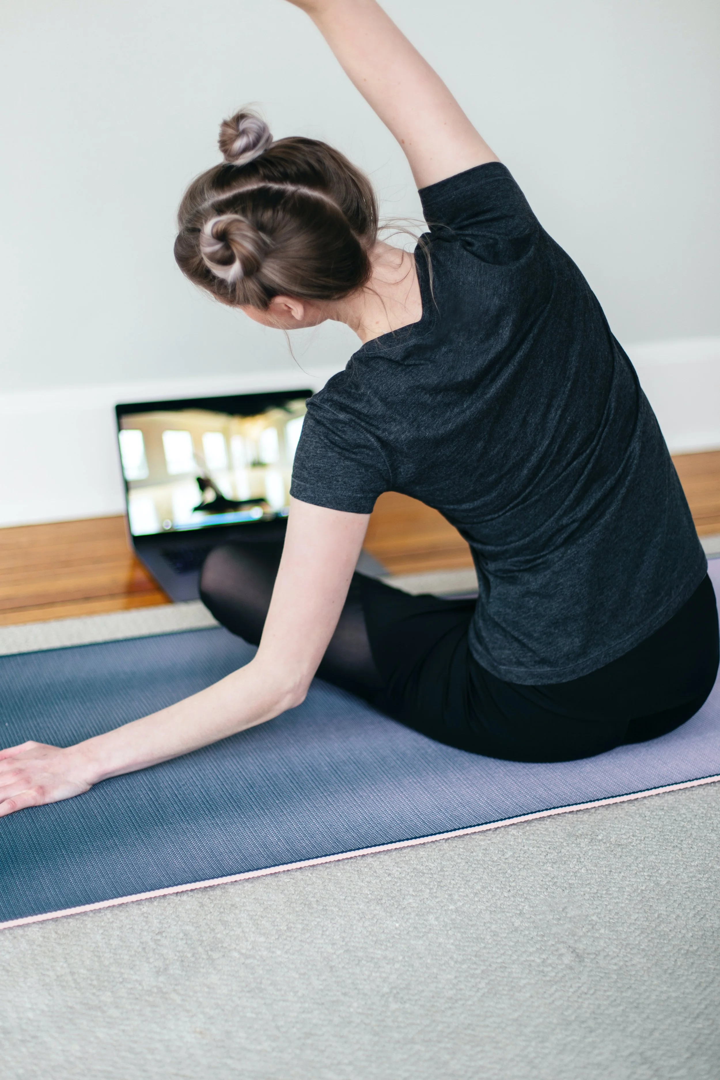 woman stretch virtual training laptop