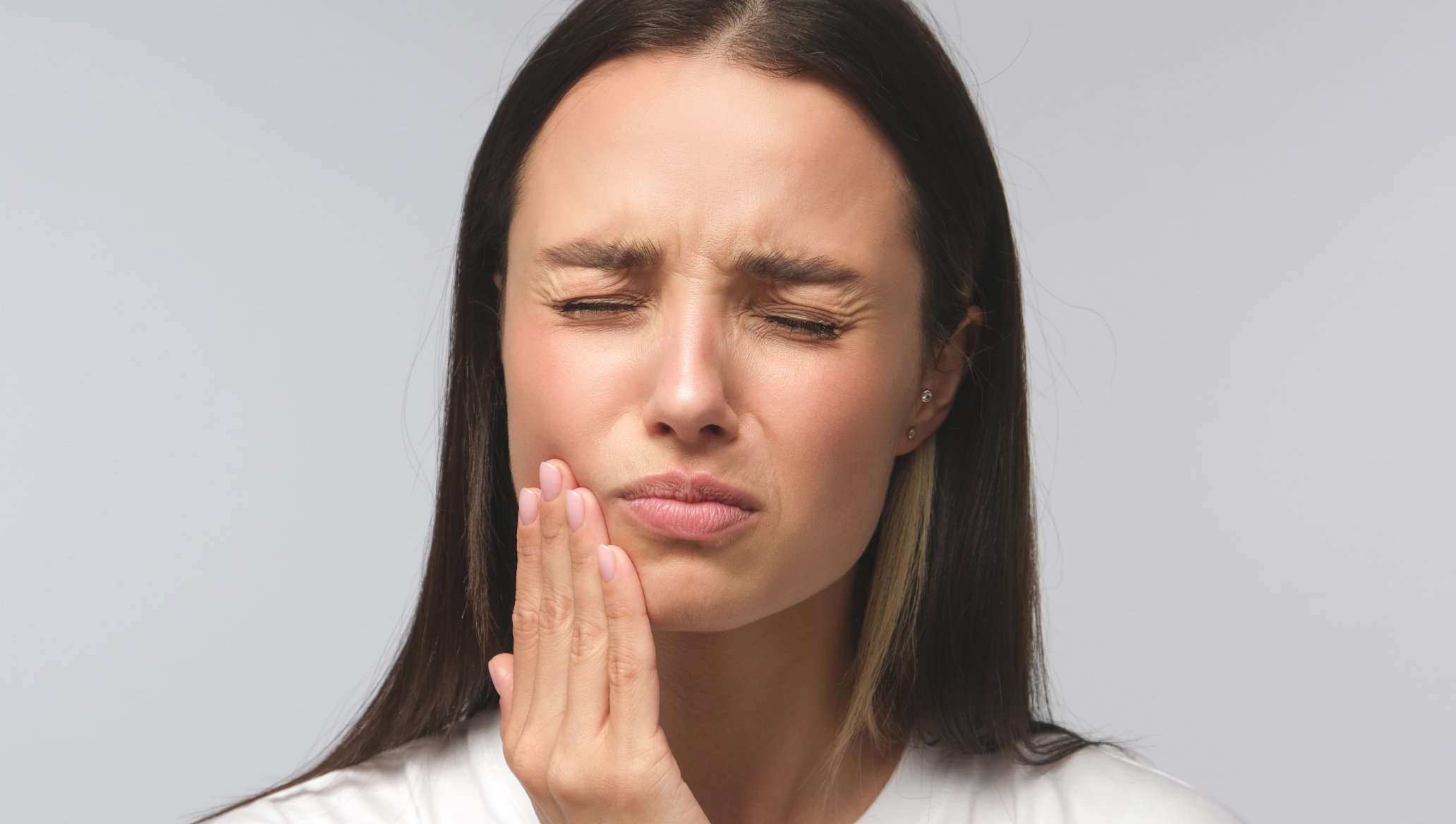 Person with hand on face, appearing to be in dental pain.