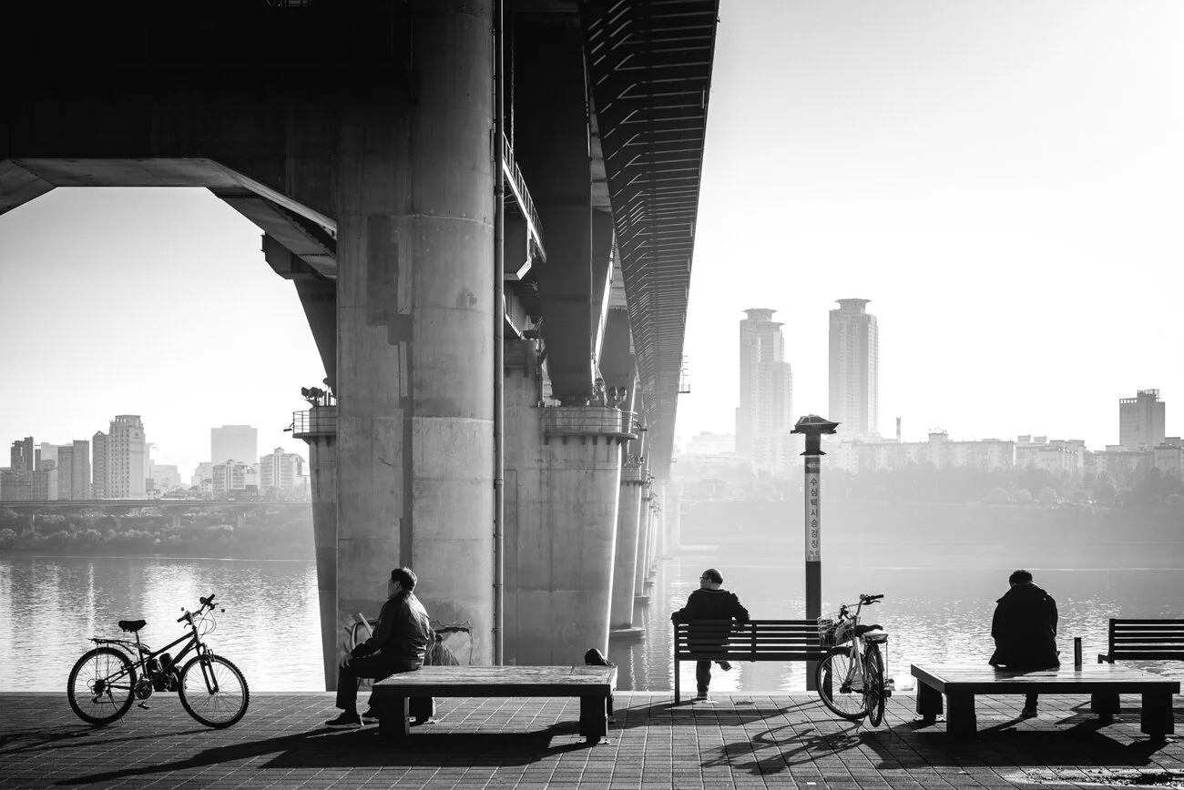 Black and white photography of koreans looking at the view from the river in Ttukseom