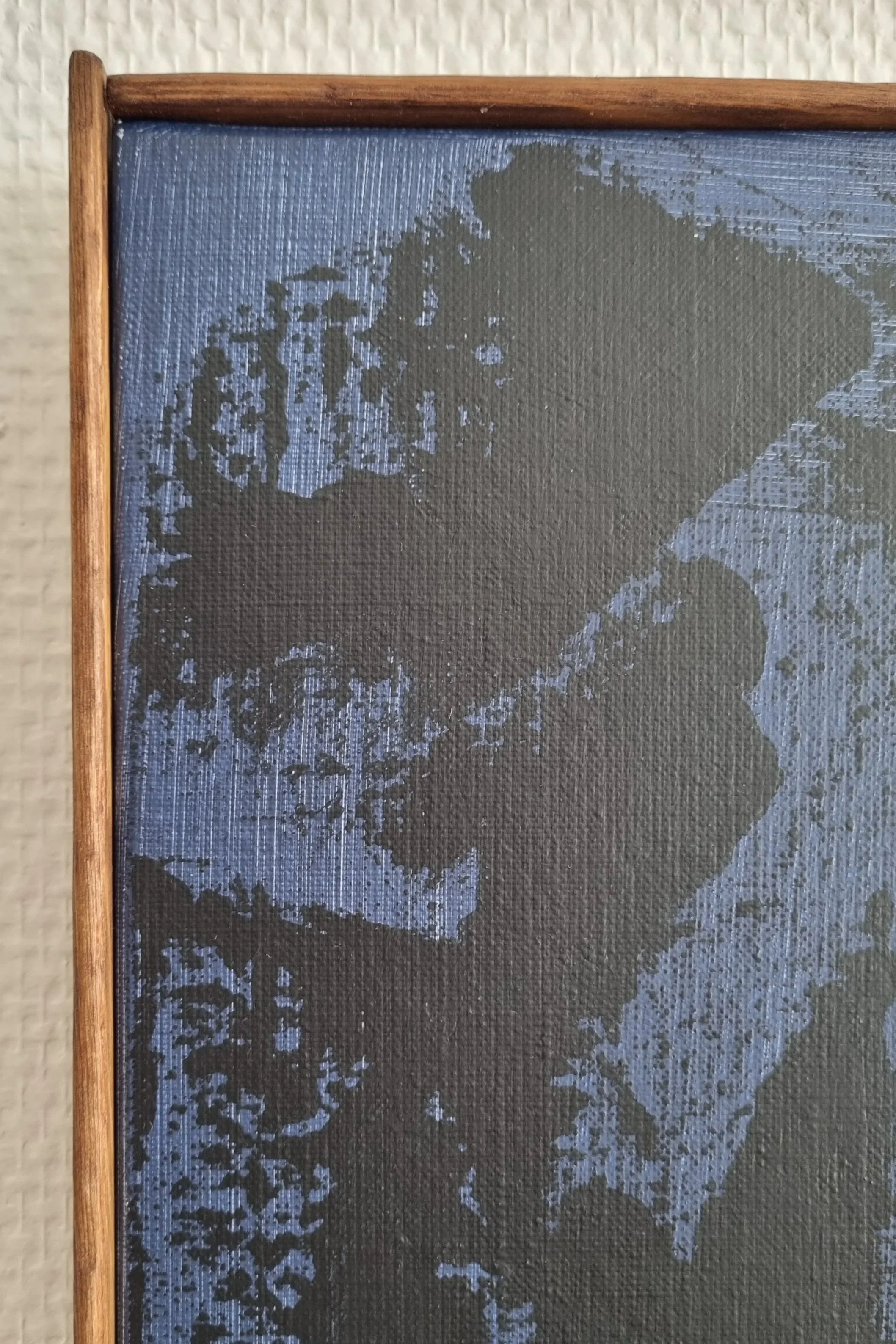 Ceci est une peinture encadrée avec un fond de couleur noire et des images en gris se détachant, représentant probablement une scène avec des arbres ou de la nature, encadrée par un cadre en bois.