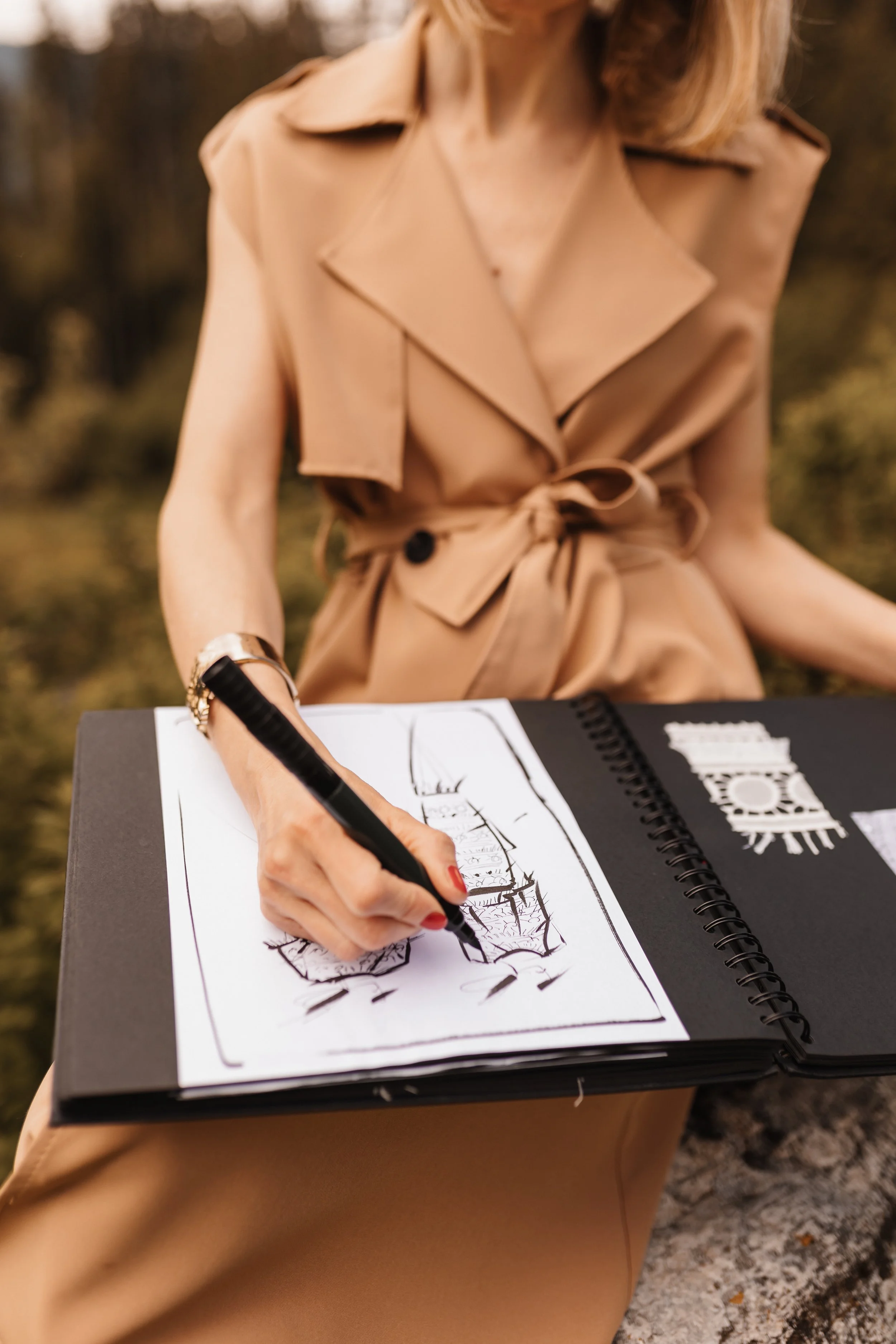 Frau zeichnet Skizzen eines Gebäudes in einem Skizzenbuch im Freien.