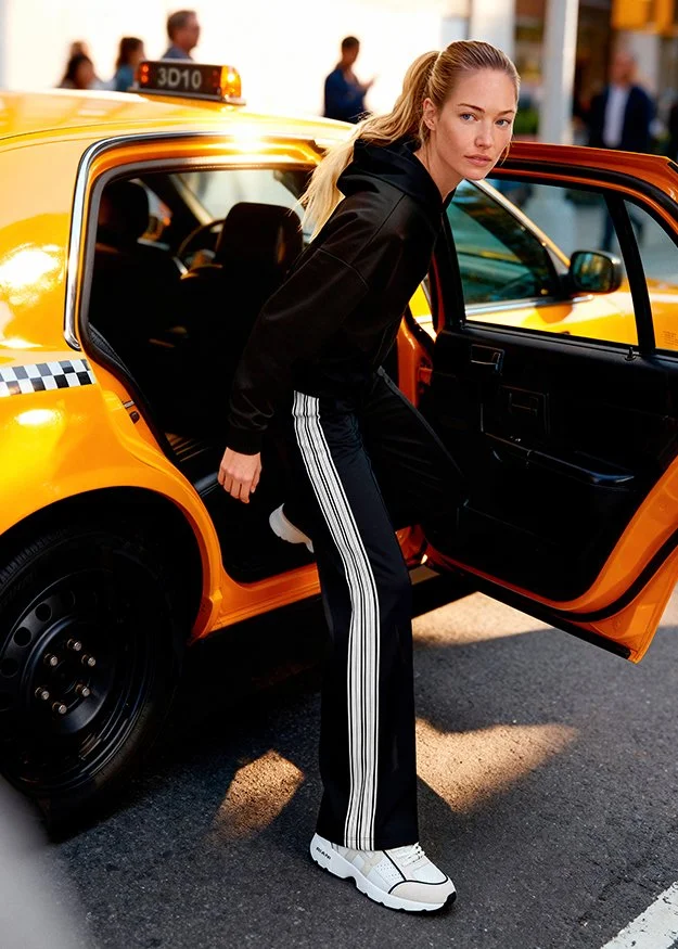 Junge Frau steigt in einen gelben Taxis.