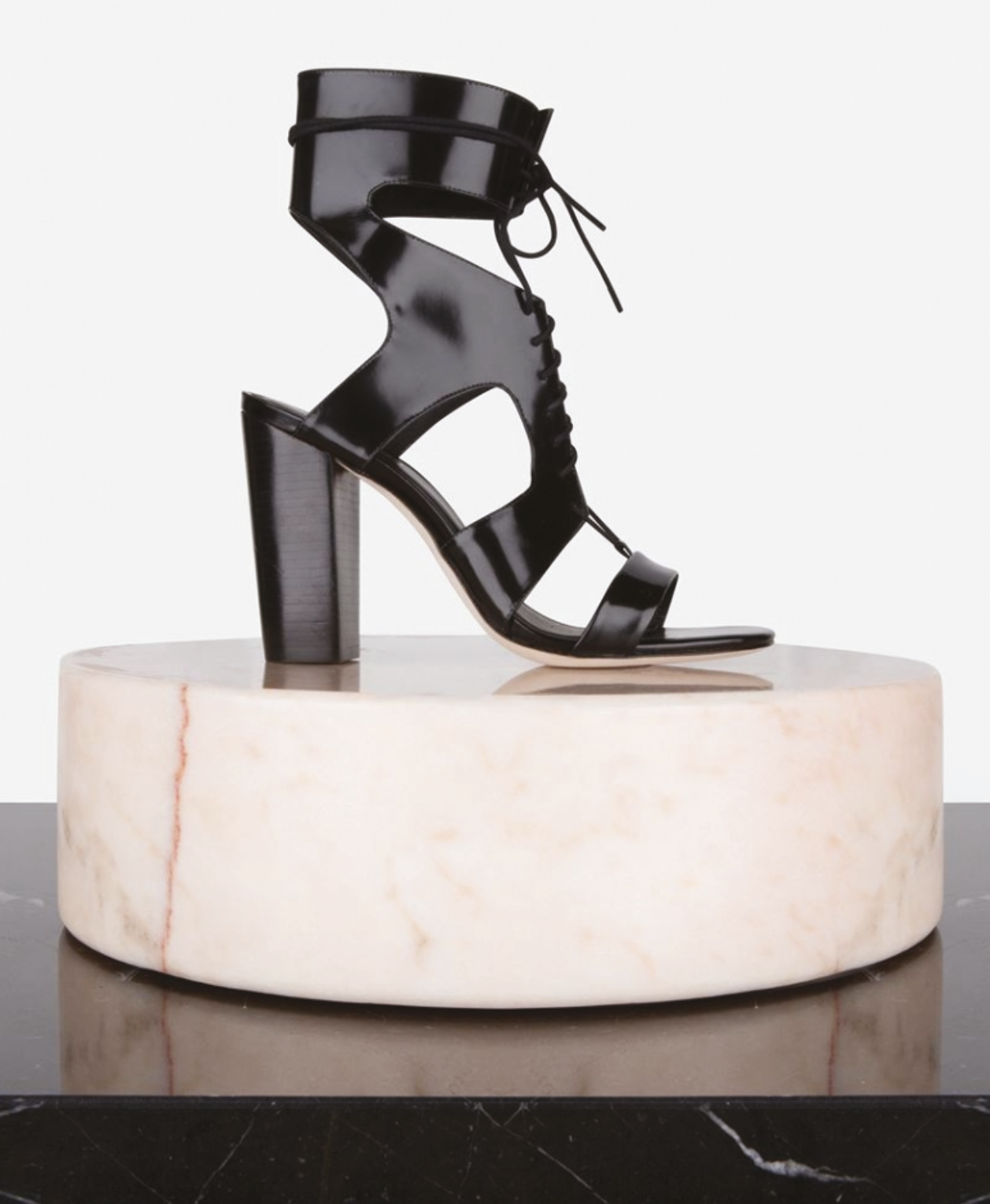 Schwarzes High-Heel-Sandal auf einem weißen Marmor-Sockel. Designed by Elisabeth Reinhartshuber