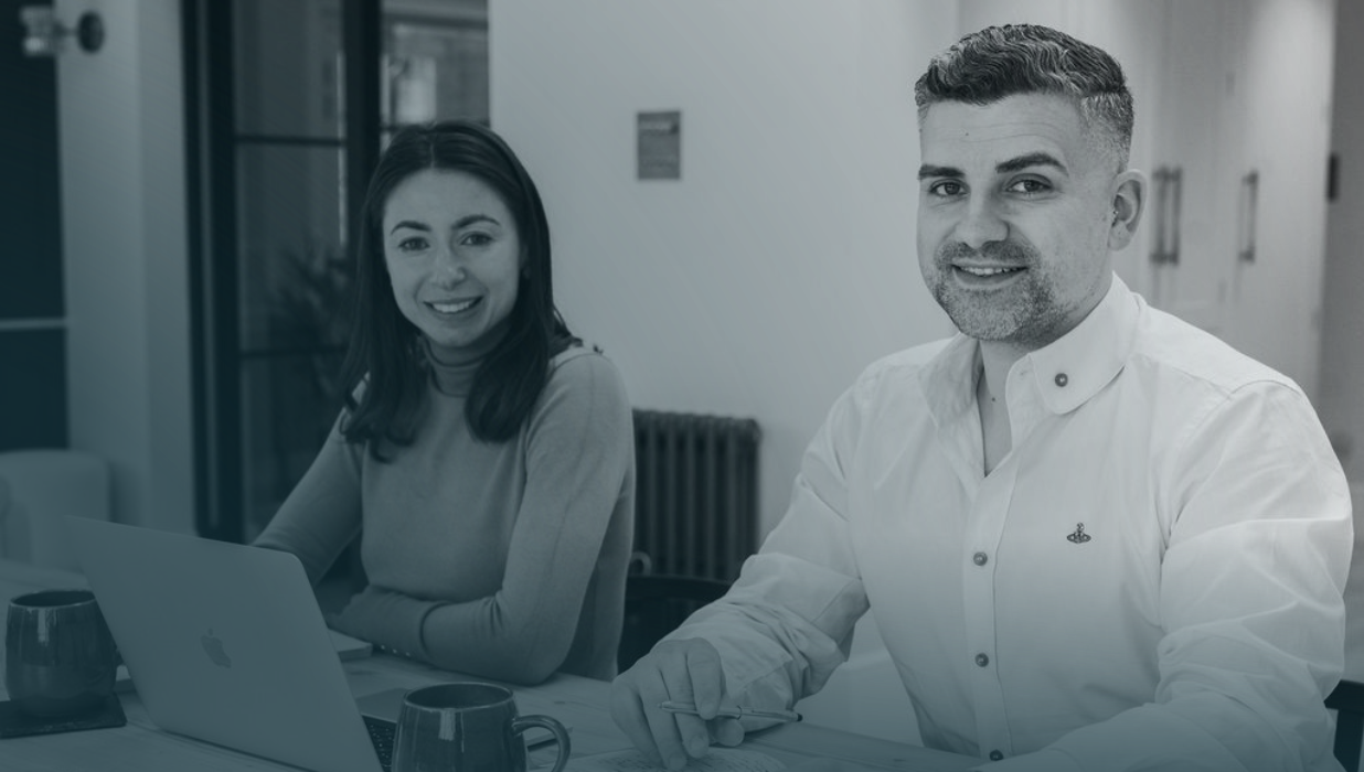 Two consultants collaborating at a laptop during a project discussion