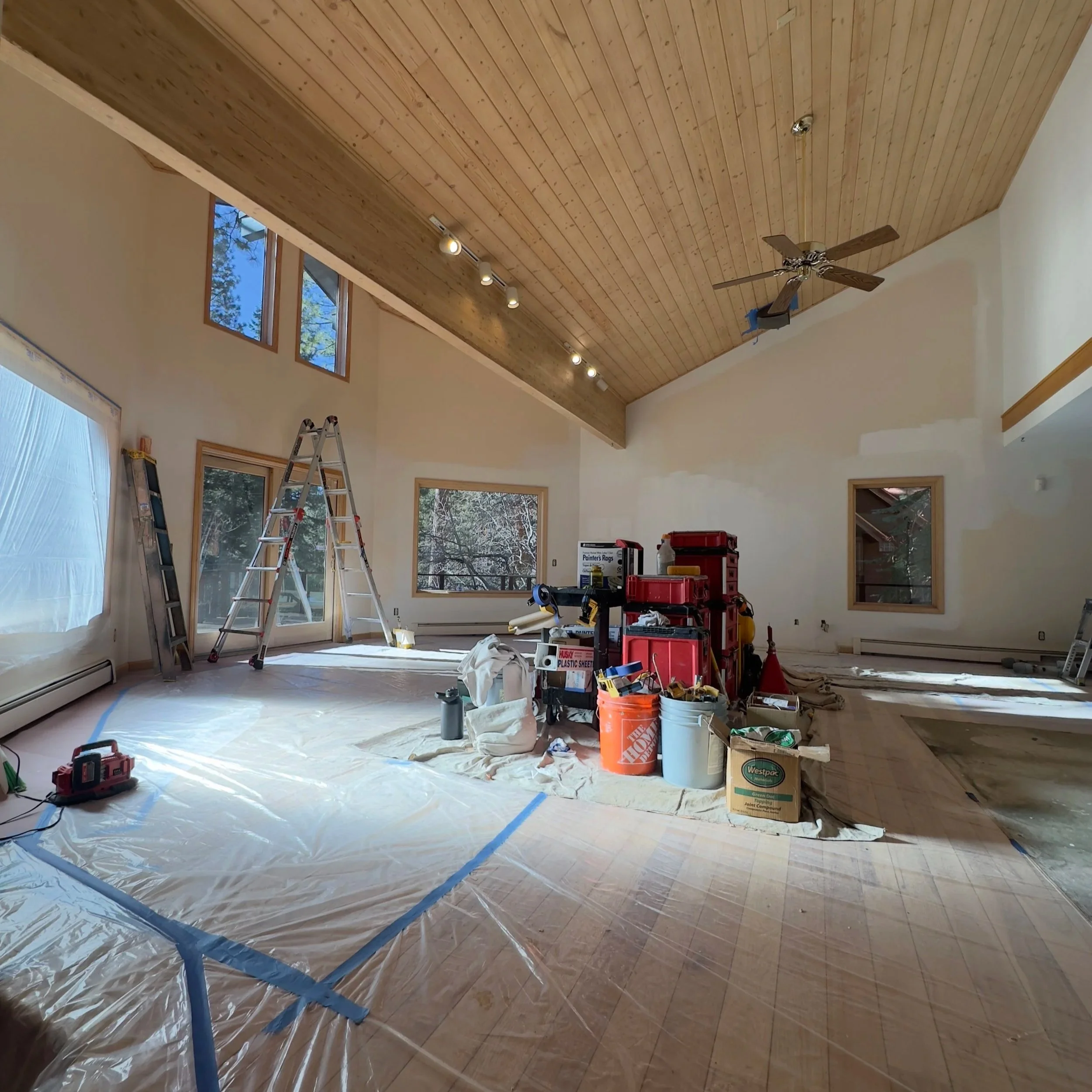 Vaulted living room with a tongue-and-groove wood ceiling, masked and prepped for interior painting in Lake Tahoe