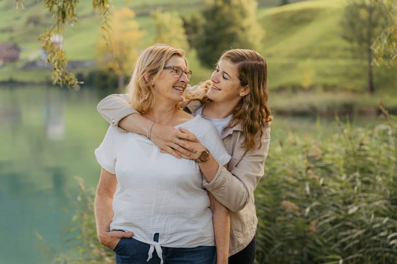 Mutter-Tochter-Bild, in grüner Landschaft mit See im Hintergrund.