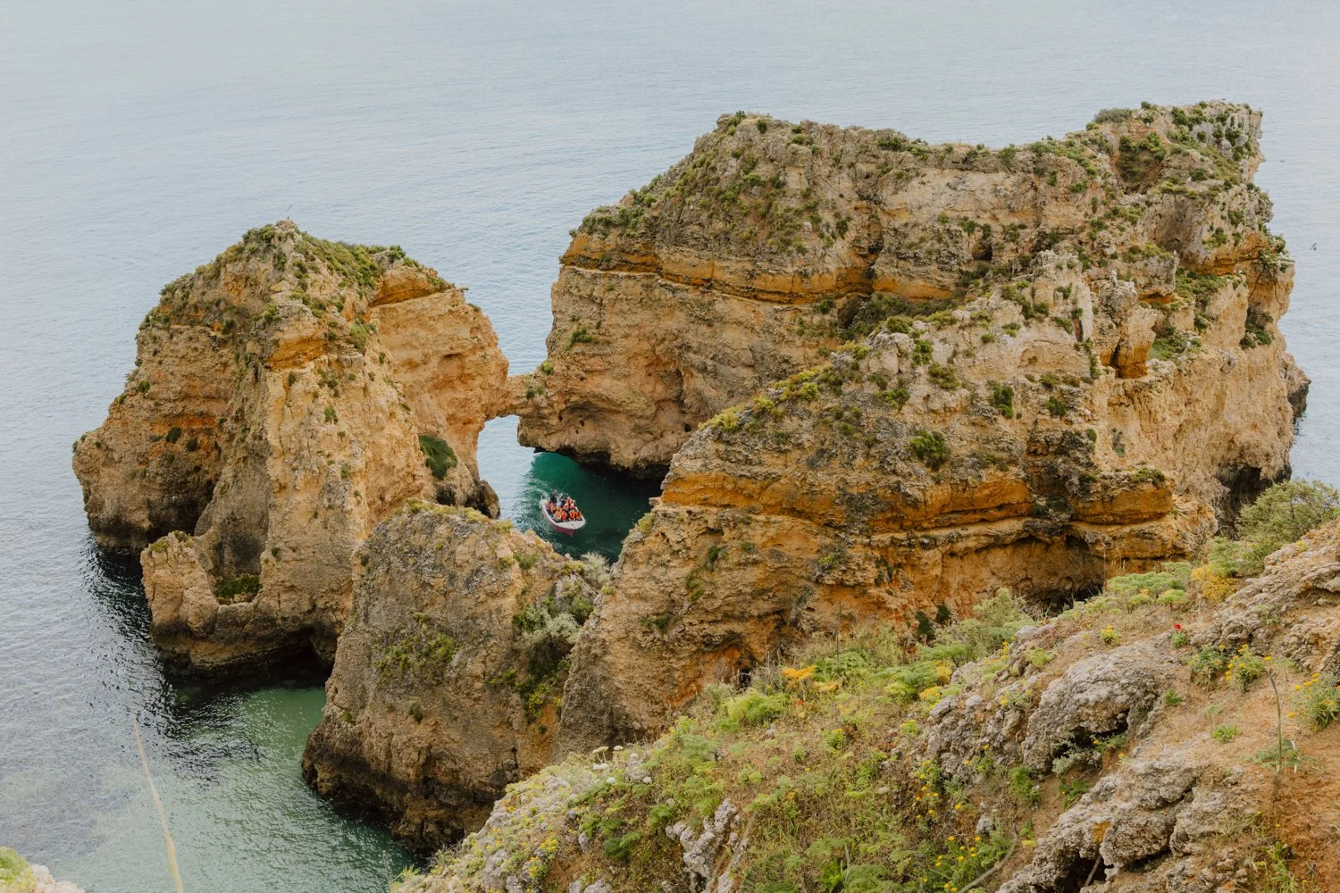 Felsenformation mit einem Boot in der Mitte im Portugiesische Meer