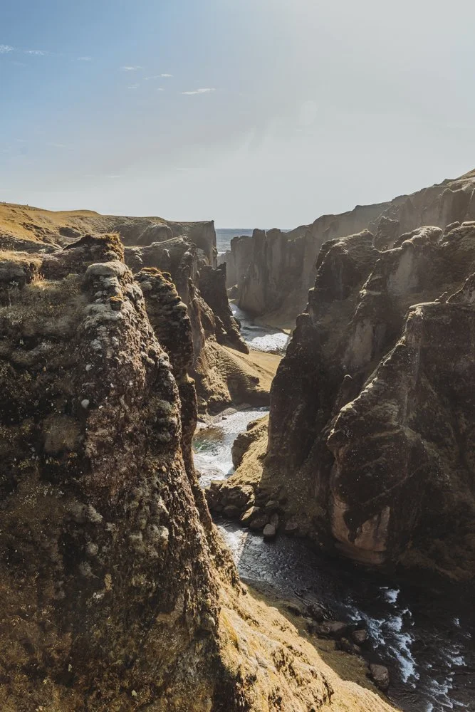 Mossige Klippen in Island mit kleinem Fluss