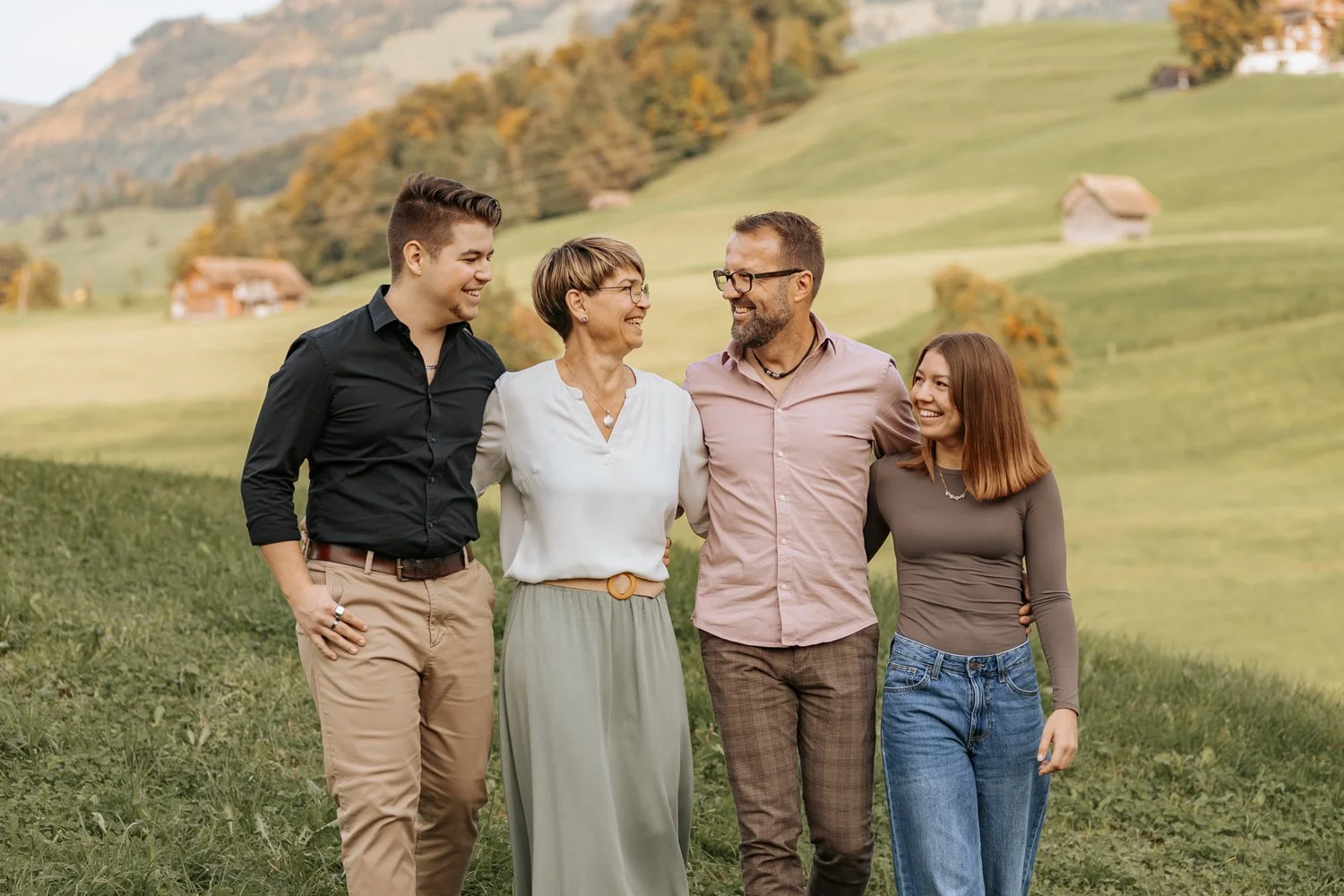 Familie beim Spaziergang in der Zentralschweiz an einem sonnigen Herbstabend.