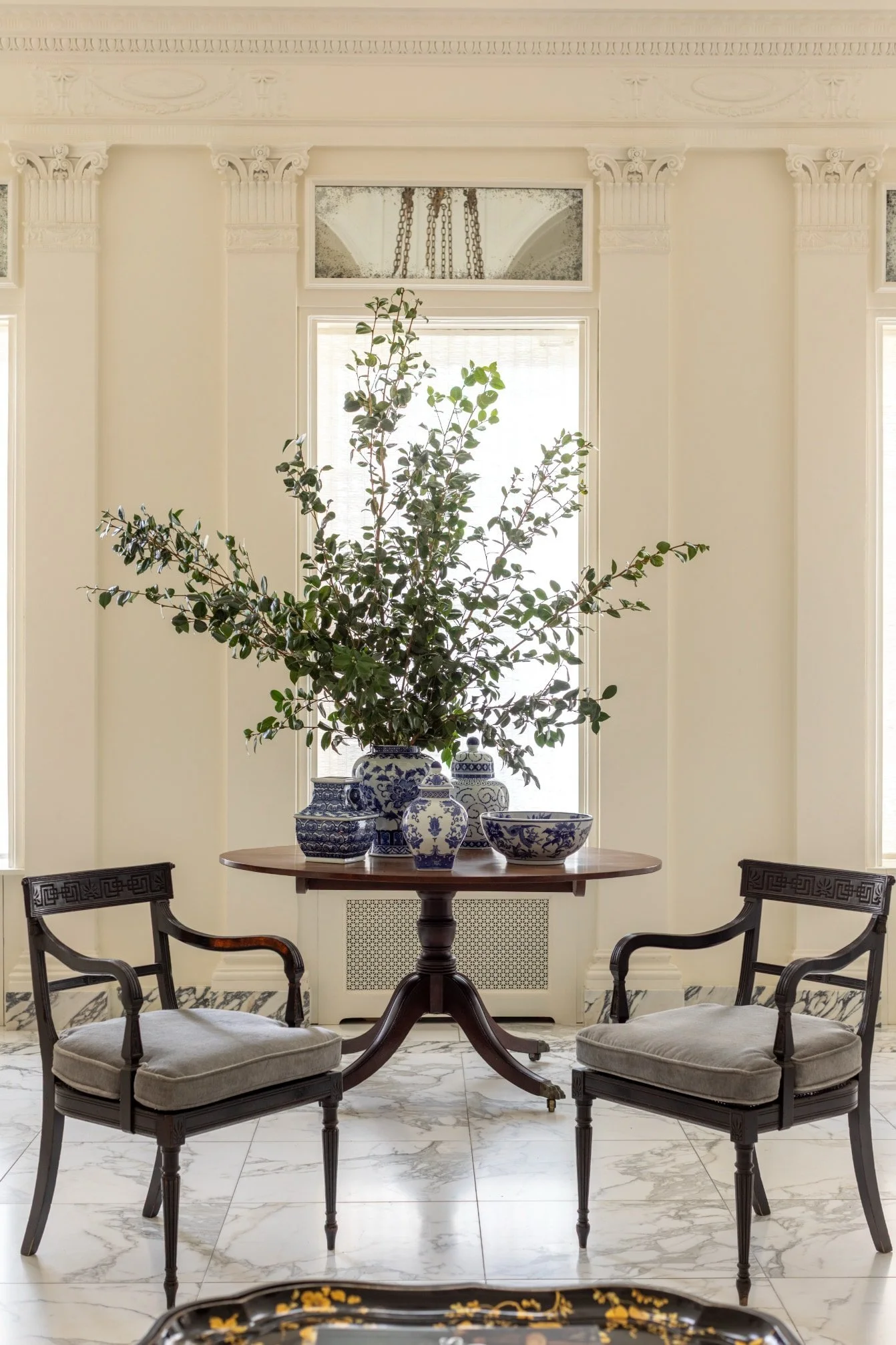 The space is thoughtfully arranged with elegant yet cozy furnishings—plush sofas in neutral tones, a textured rug beneath, and a simple wooden table that grounds the room with natural warmth.