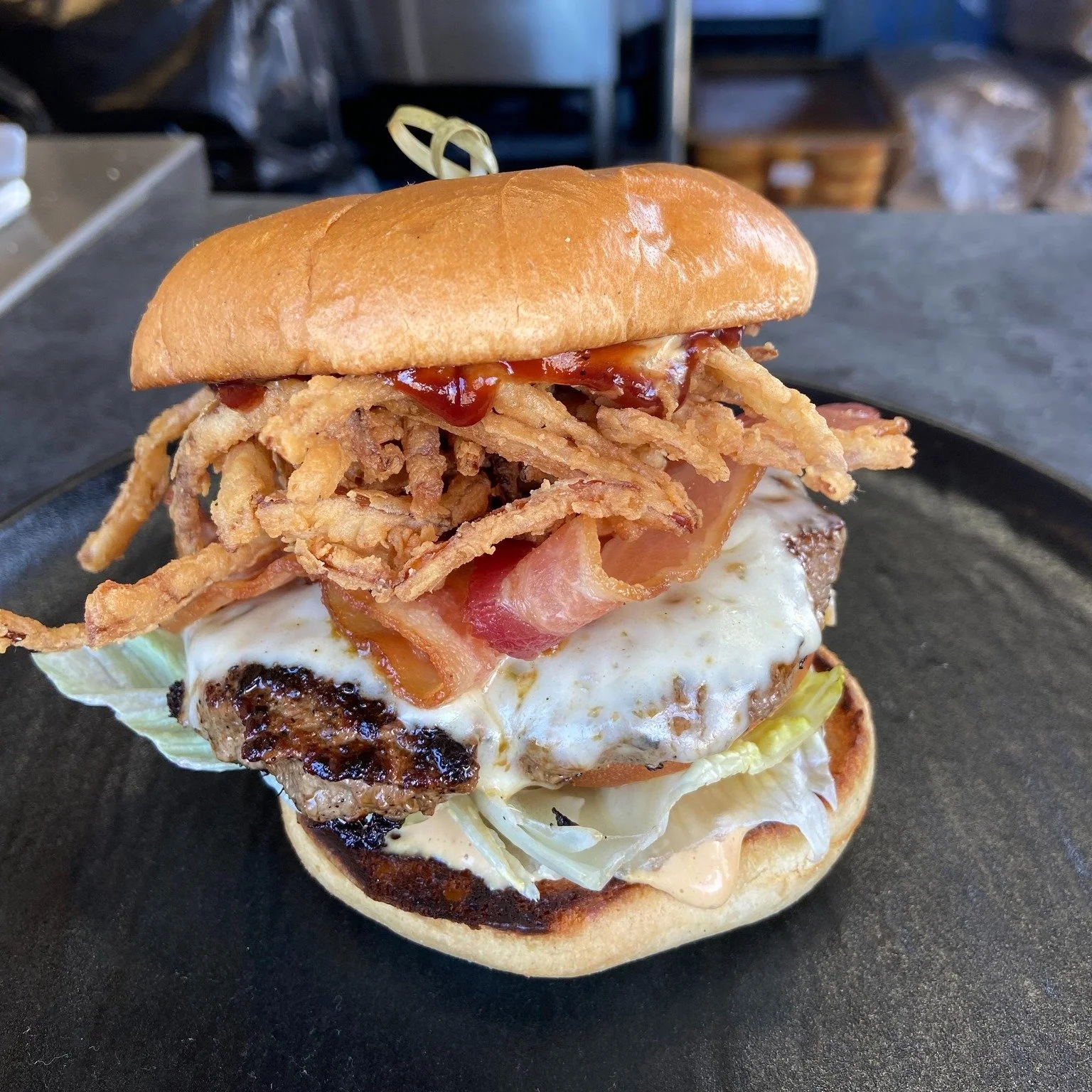 🤠The Cowboy Burger

Take a bite into a juicy grass-fed grass-finished 1/3lb (6oz) hamburger patty, topped with melted pepper jack cheese. Cover in crispy onion strings, thick cut bacon, and tangy BBQ sauce on our branded 4B bun. All orders come with