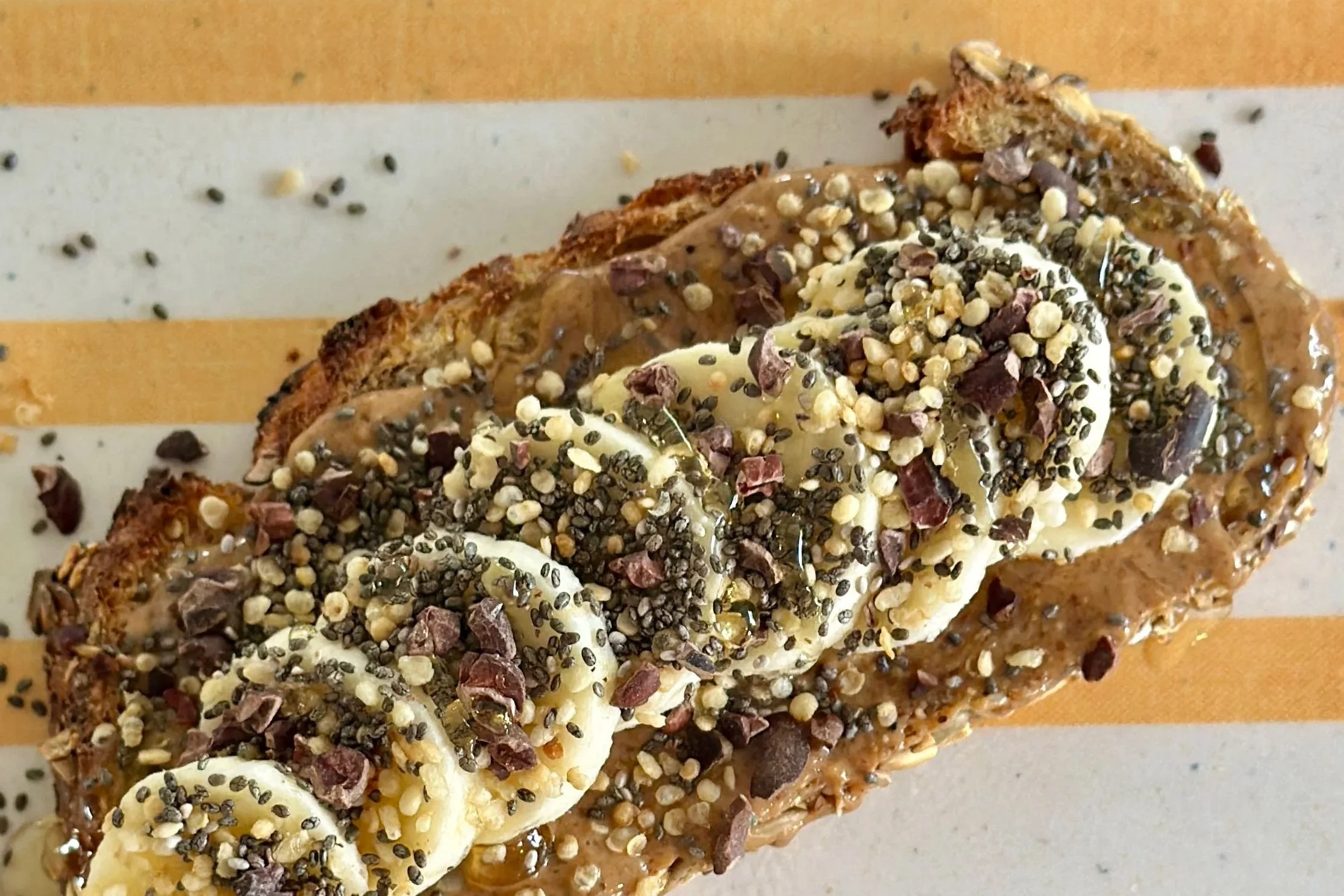 Sourdough toast with natural peanut butter, sliced bananas and sprinkled with TOP'T cacao crunch