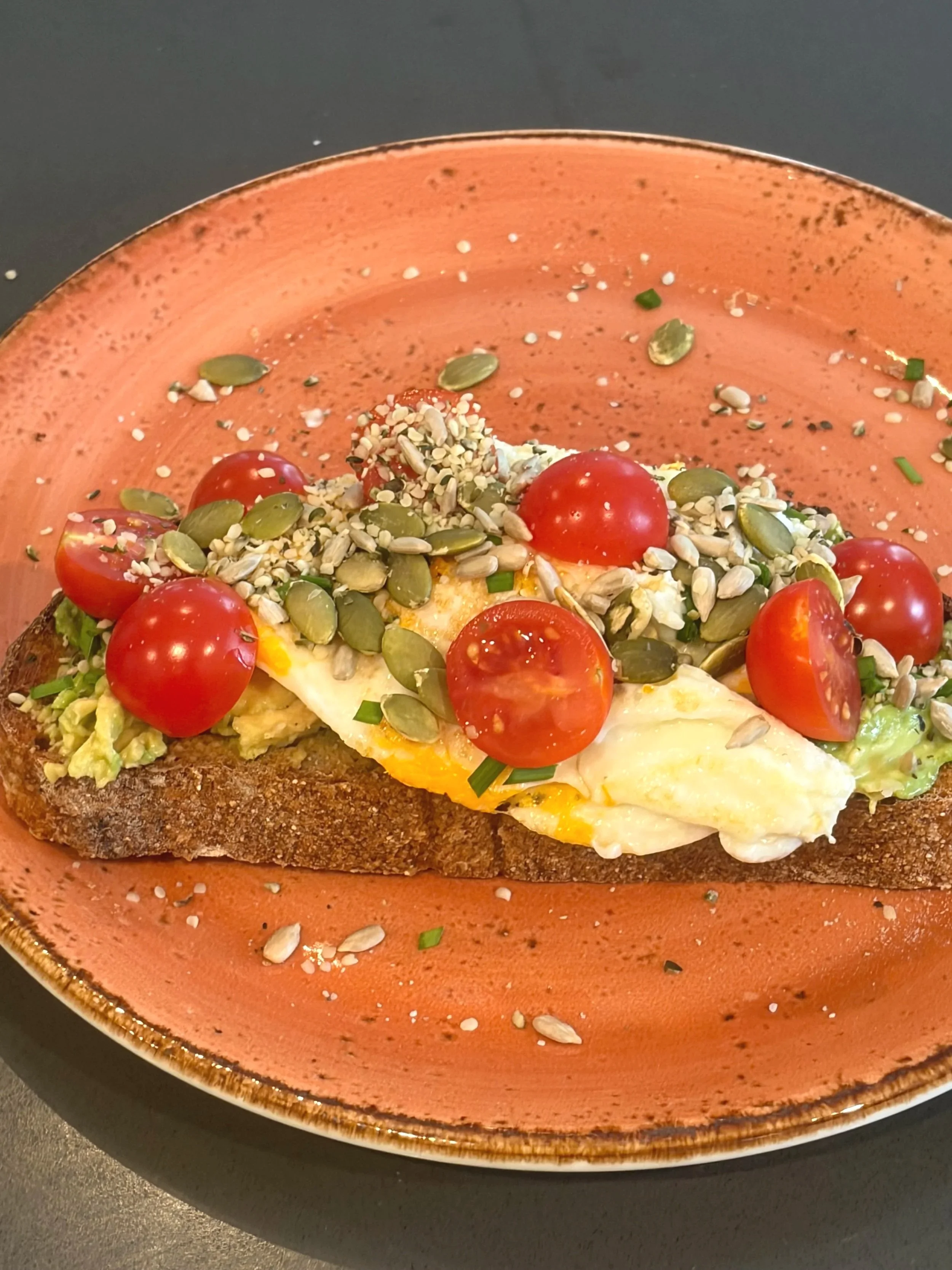 Avocado and egg toast with cherry tomatoes, chives and TOP'T Seed Mix.