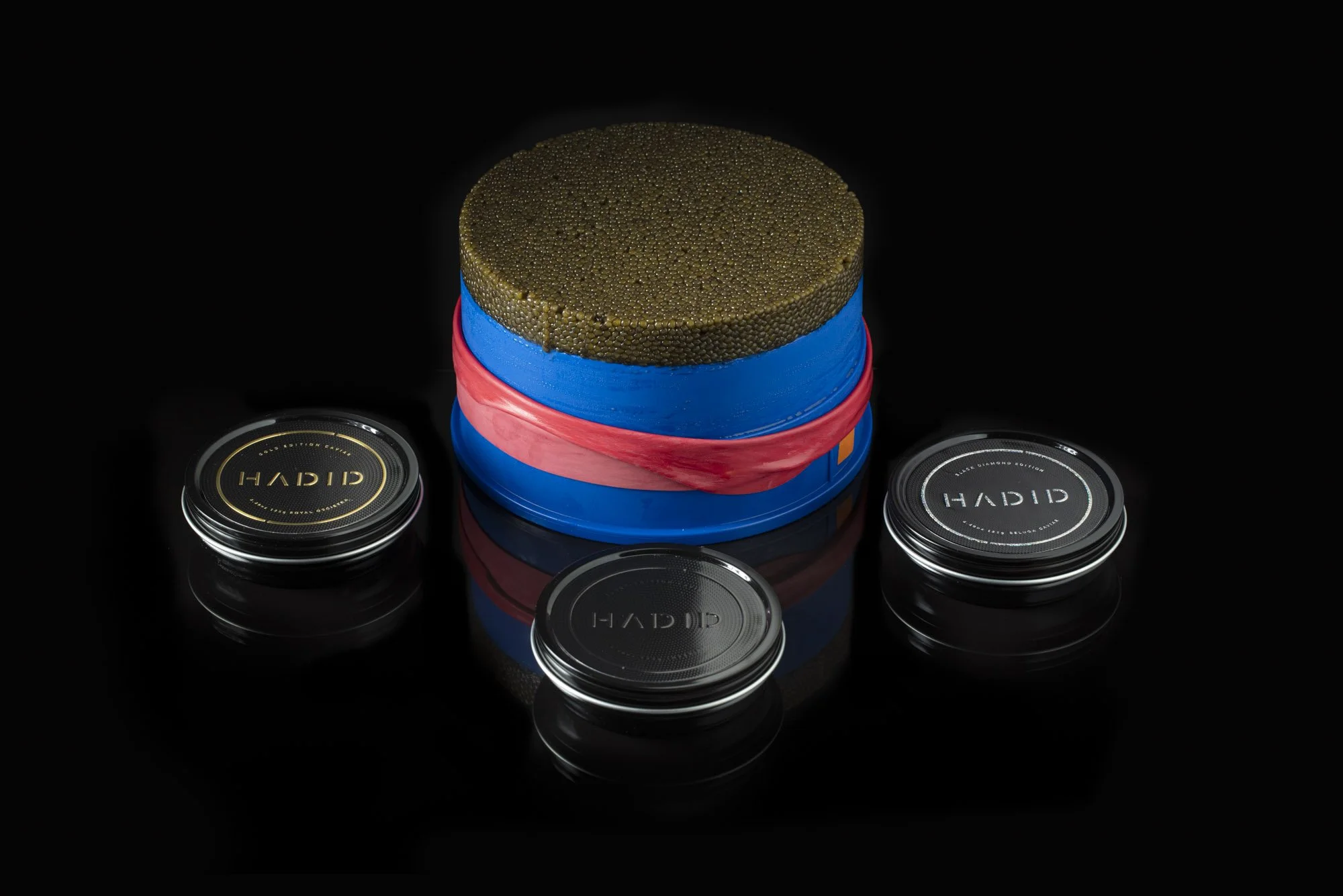 Hadid Caviar tins beside a large caviar tin