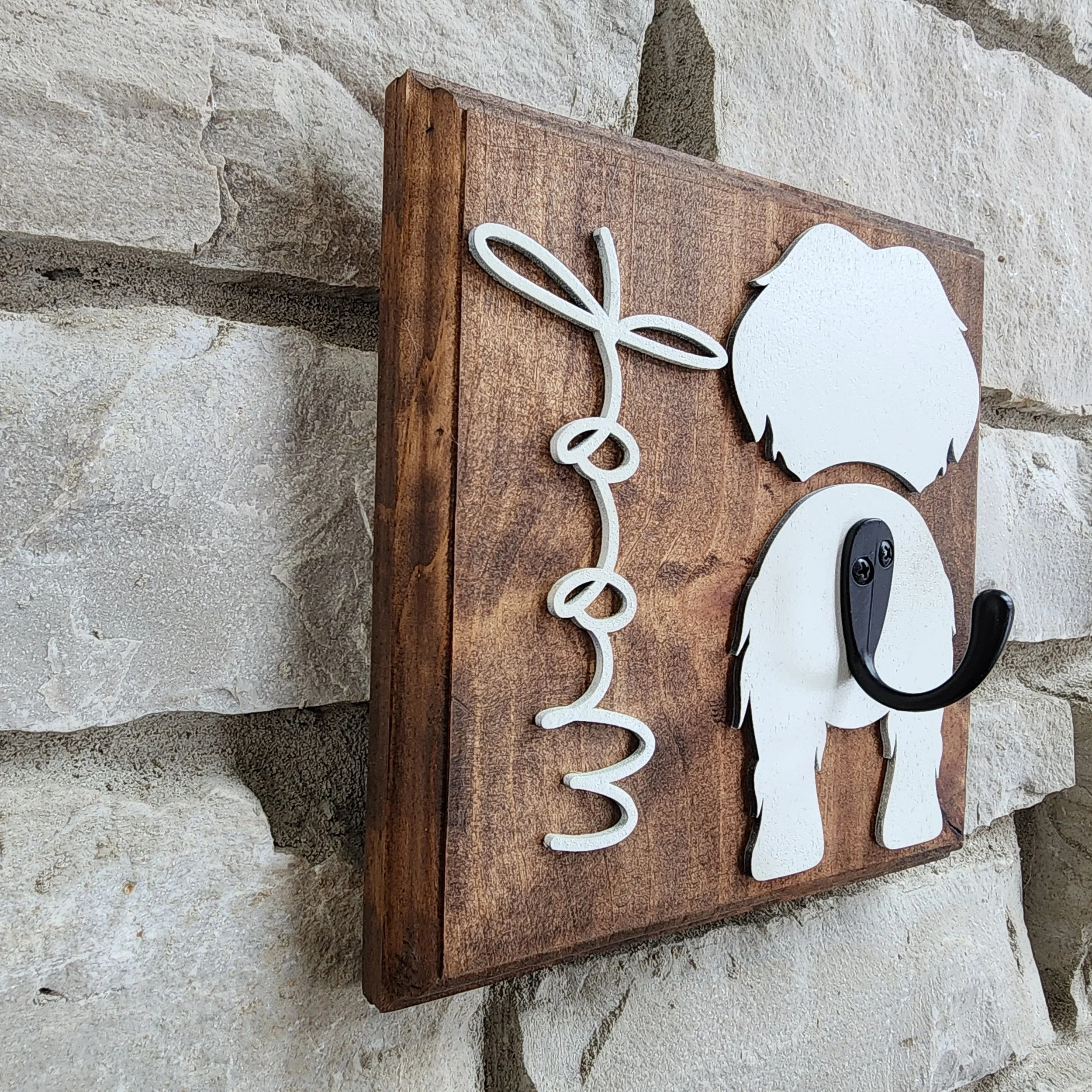 Maltese silhouette wall hook on a wooden plaque on a neutral background