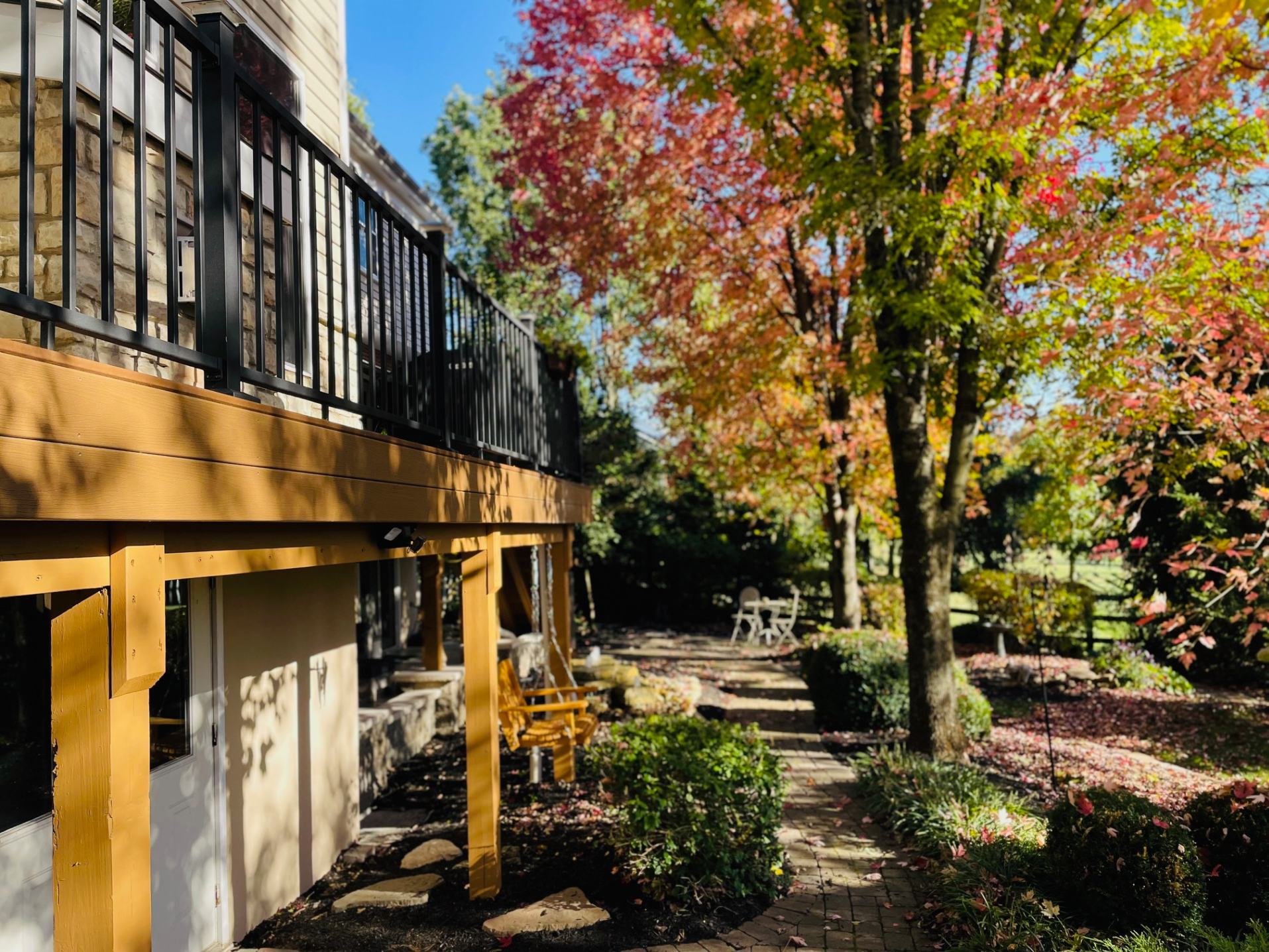 A construction project involving the addition of a balcony or a deck with a view of a tree in the fall.jpg