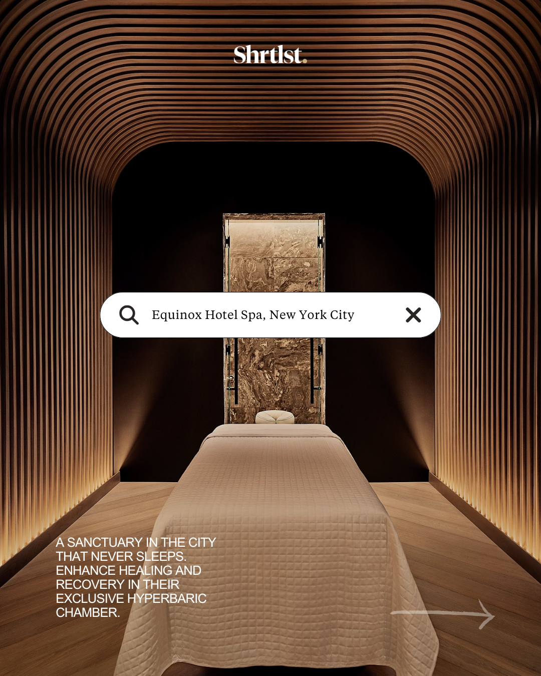 A luxurious massage room at the Equinox Hotel Spa in New York City, featuring a massage table with a cream quilted cover, wooden flooring, and curved wooden wall panels lighting softly. A search bar centered on the image shows the address; text on th
